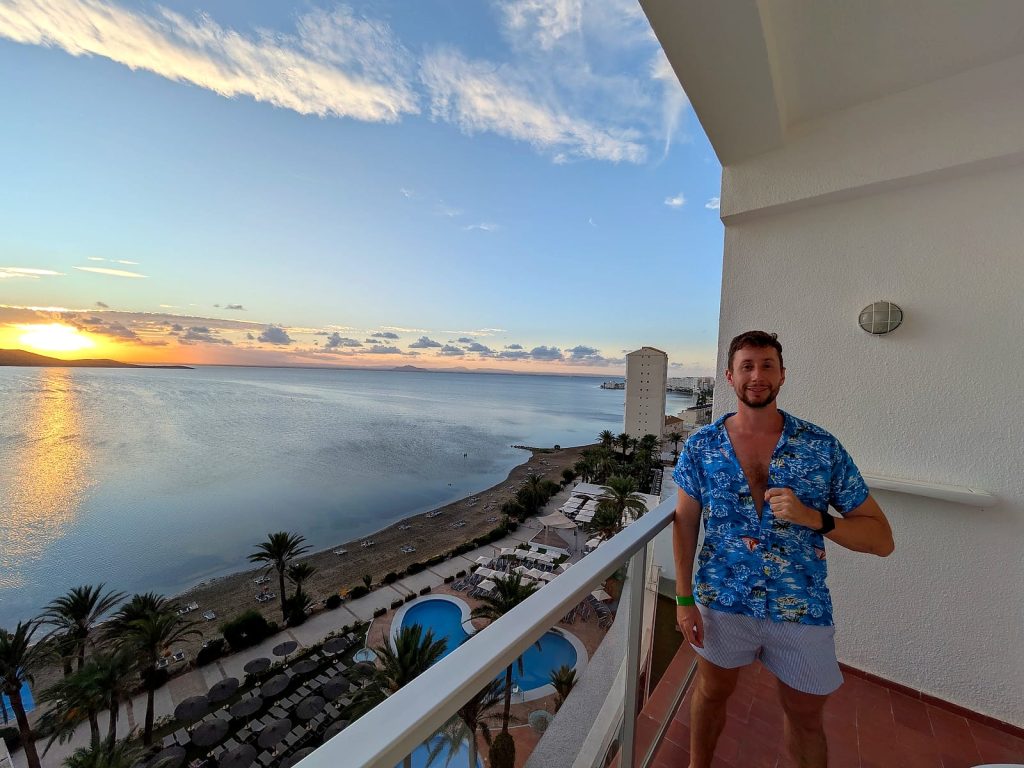 Javier Sobrino en la terraza de su habitación del AluaSun Doblemar al atardecer, con el Mar Menor y las piscinas debajo
