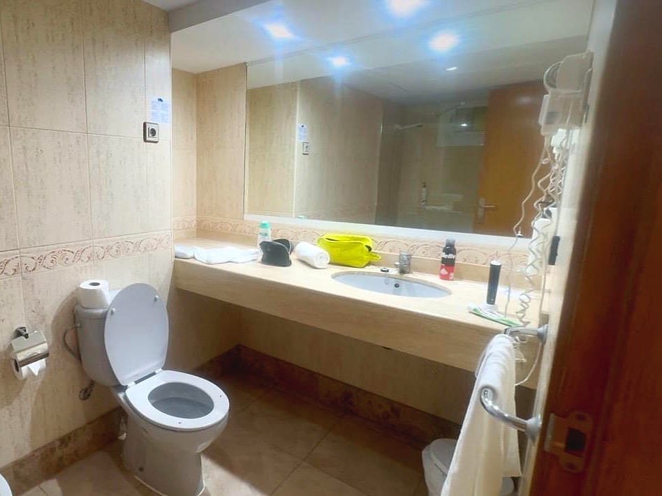 Baño del apartamento del Hotel Bahía Serena, con lavabo amplio, espejo grande e inodoro