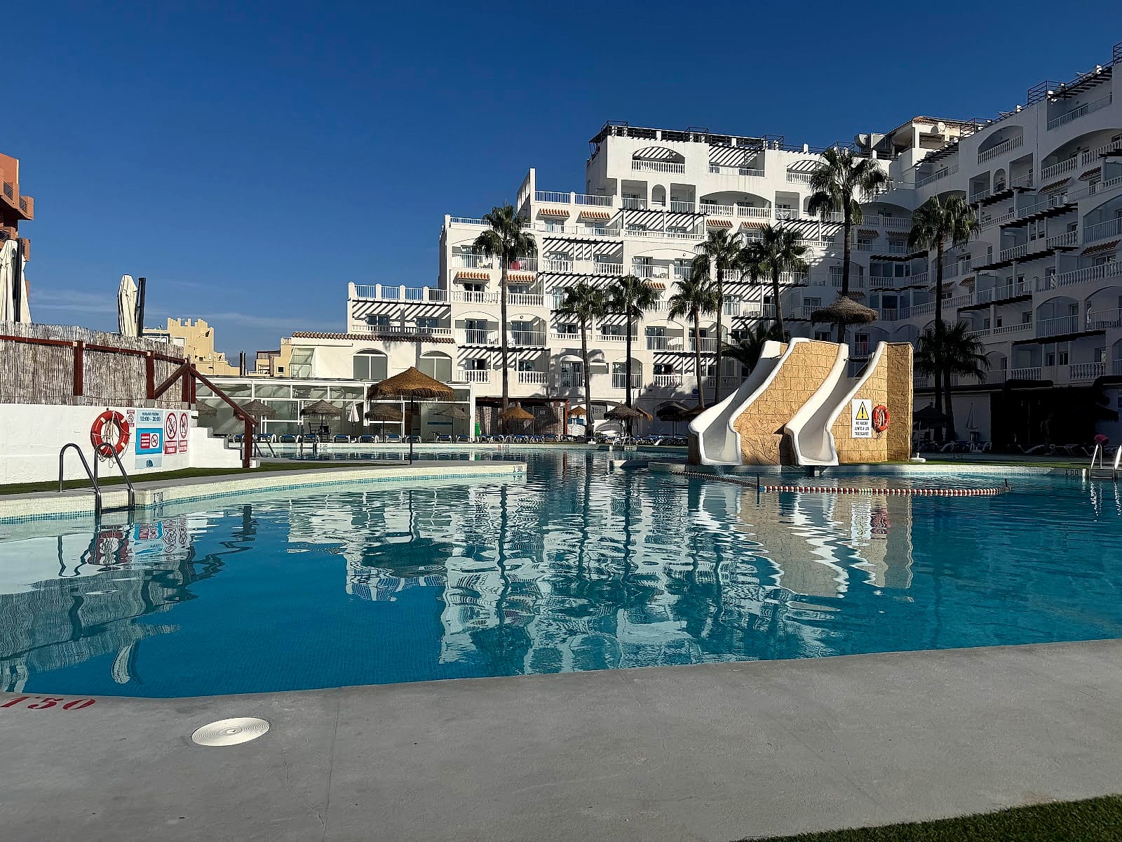La piscina del Hotel Bahía Serena a primera hora, con los dos toboganes y las hamacas vacías