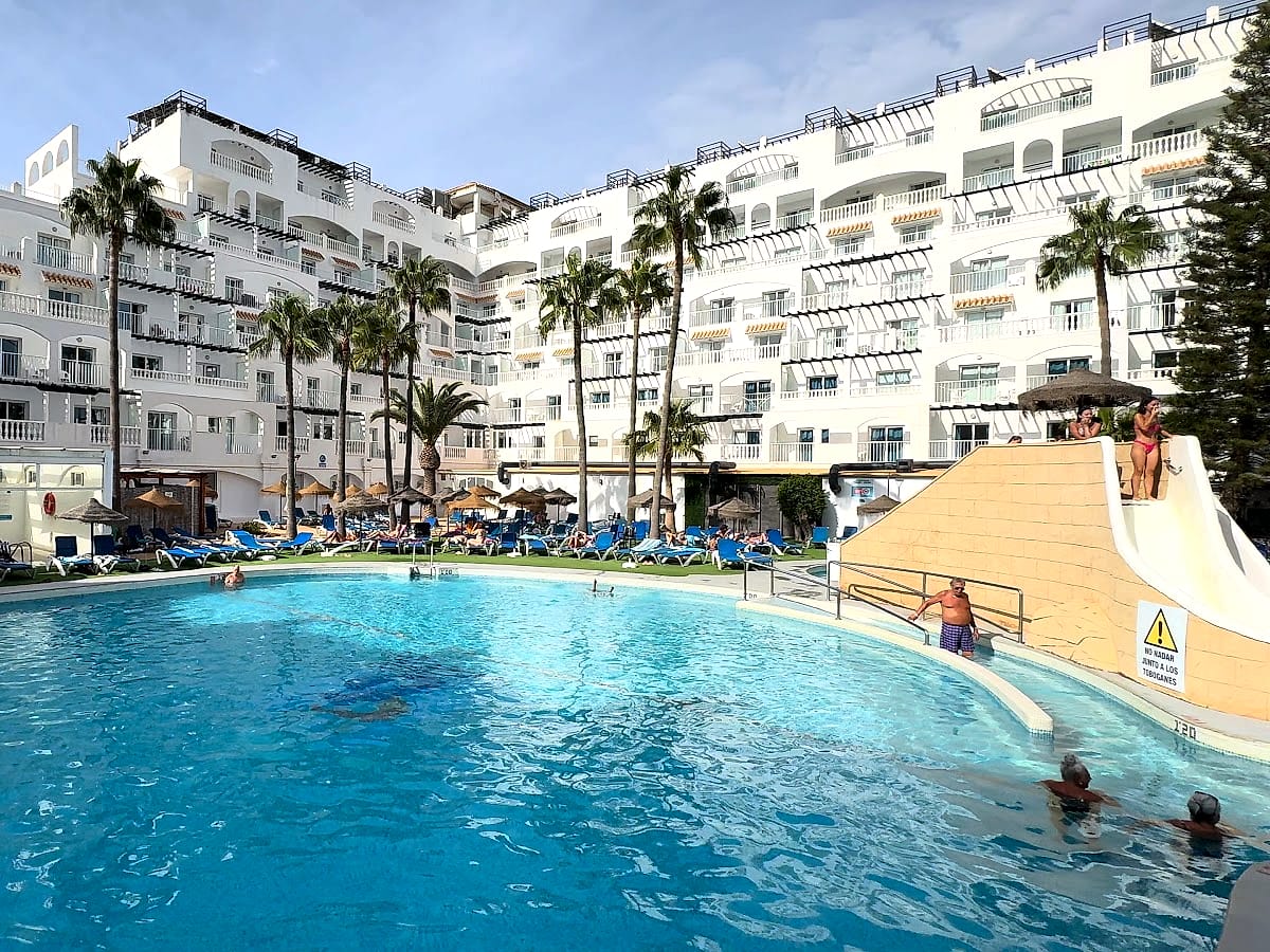 La piscina del Hotel Bahía Serena por la tarde, con los toboganes y el edificio blanco detrás