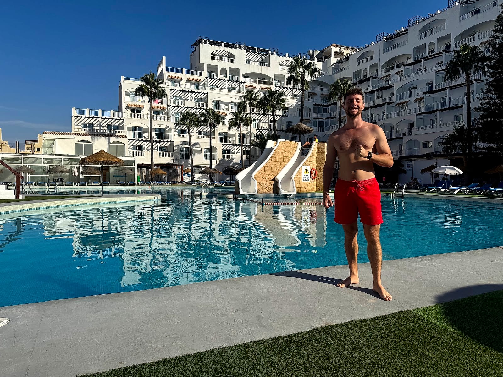 Javier Sobrino junto a la piscina del Hotel Bahía Serena, con los dos toboganes y el edificio blanco detrás