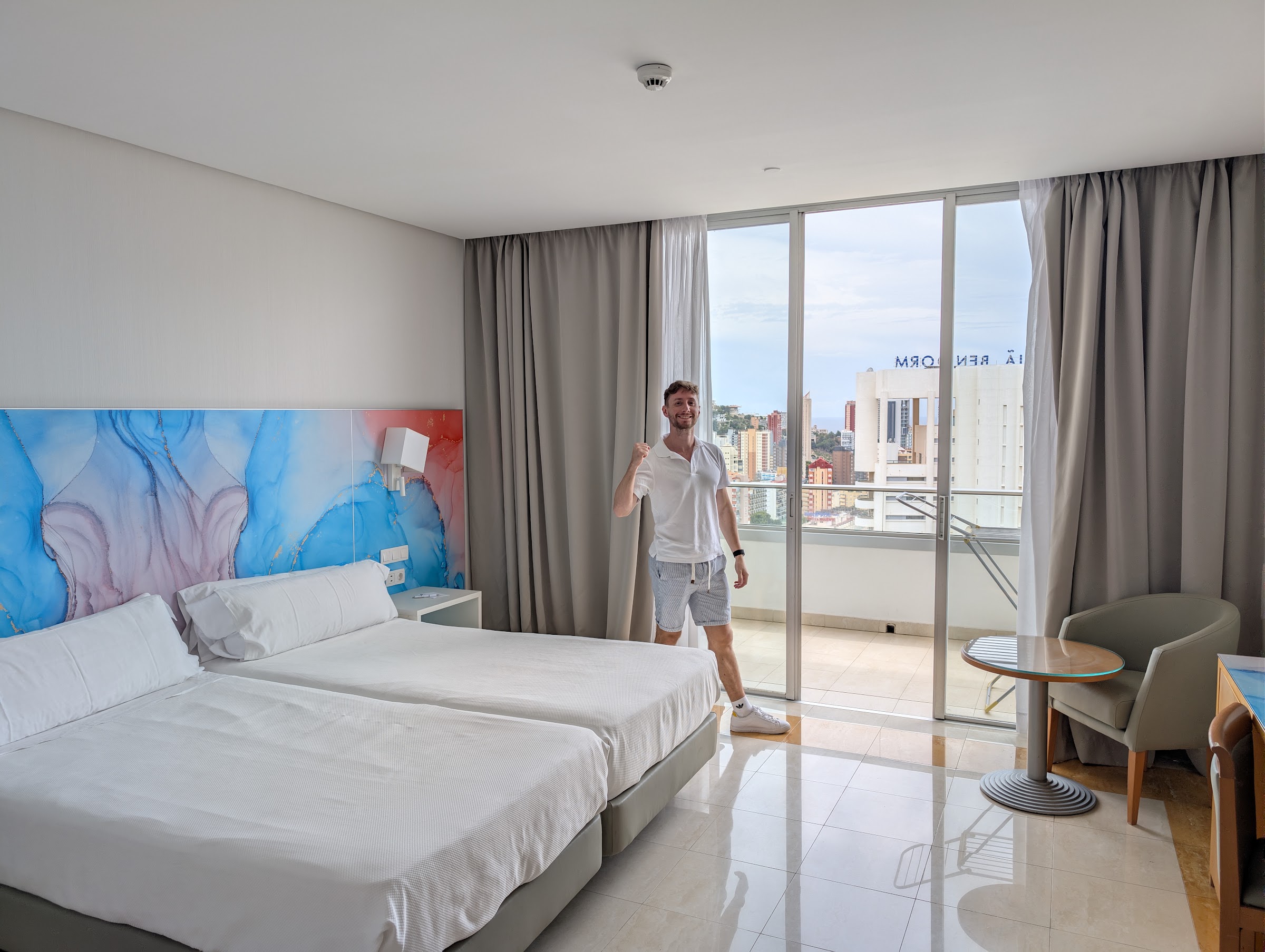 Habitación doble del BCL Levante Club con dos camas, cabecero azul y salida a la terraza
