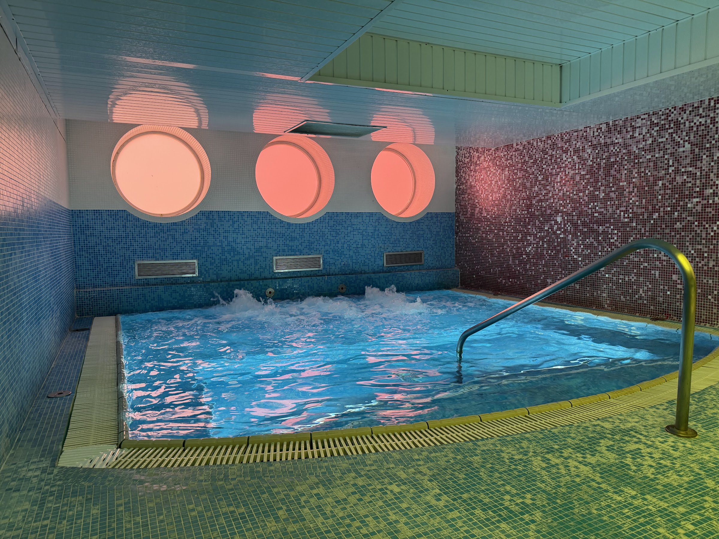 Piscina de chorros del spa del BCL Levante Club con ojos de buey iluminados en rosa