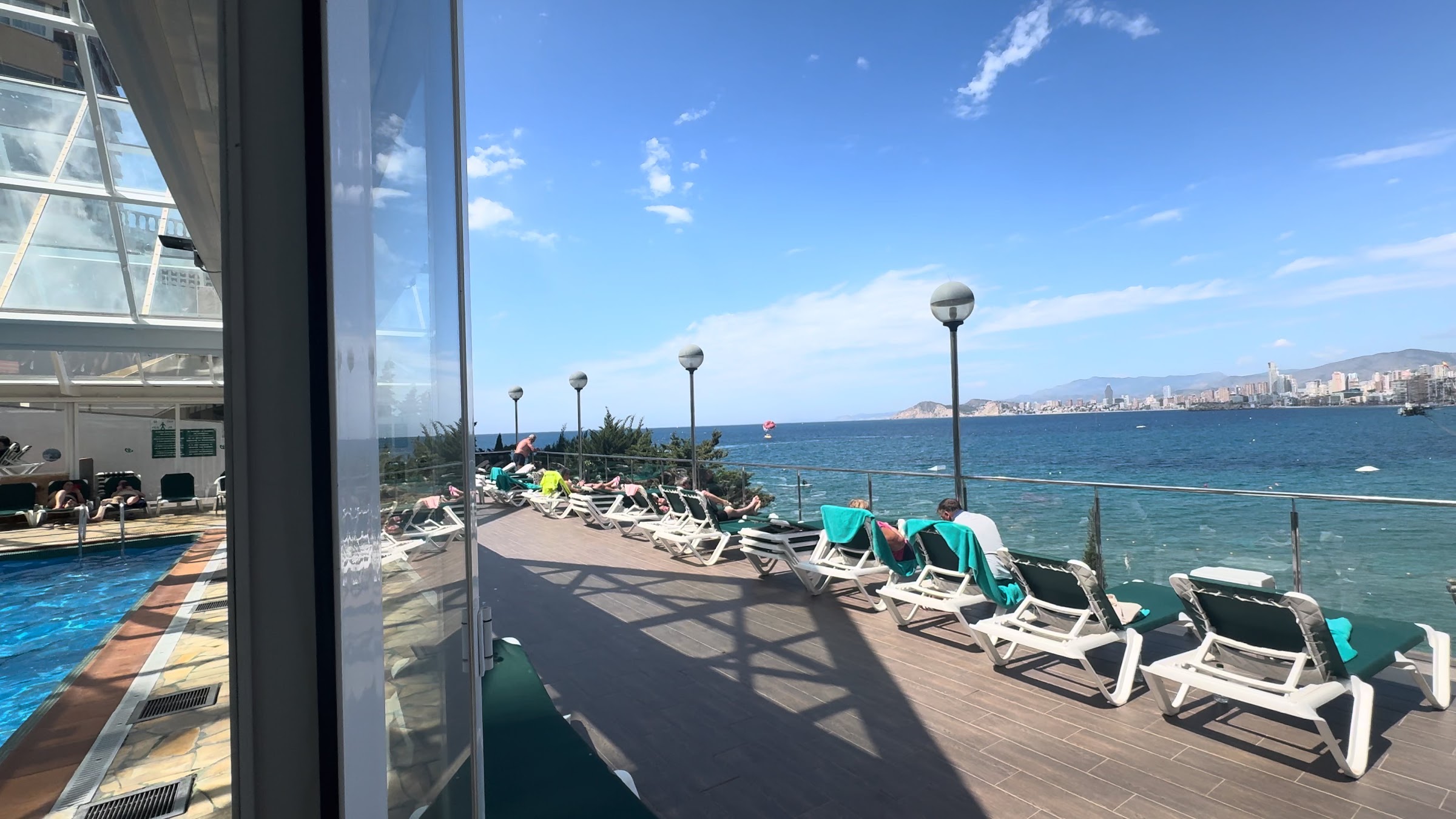 Solárium con hamacas y piscina frente al mar en el Hotel Benikaktus
