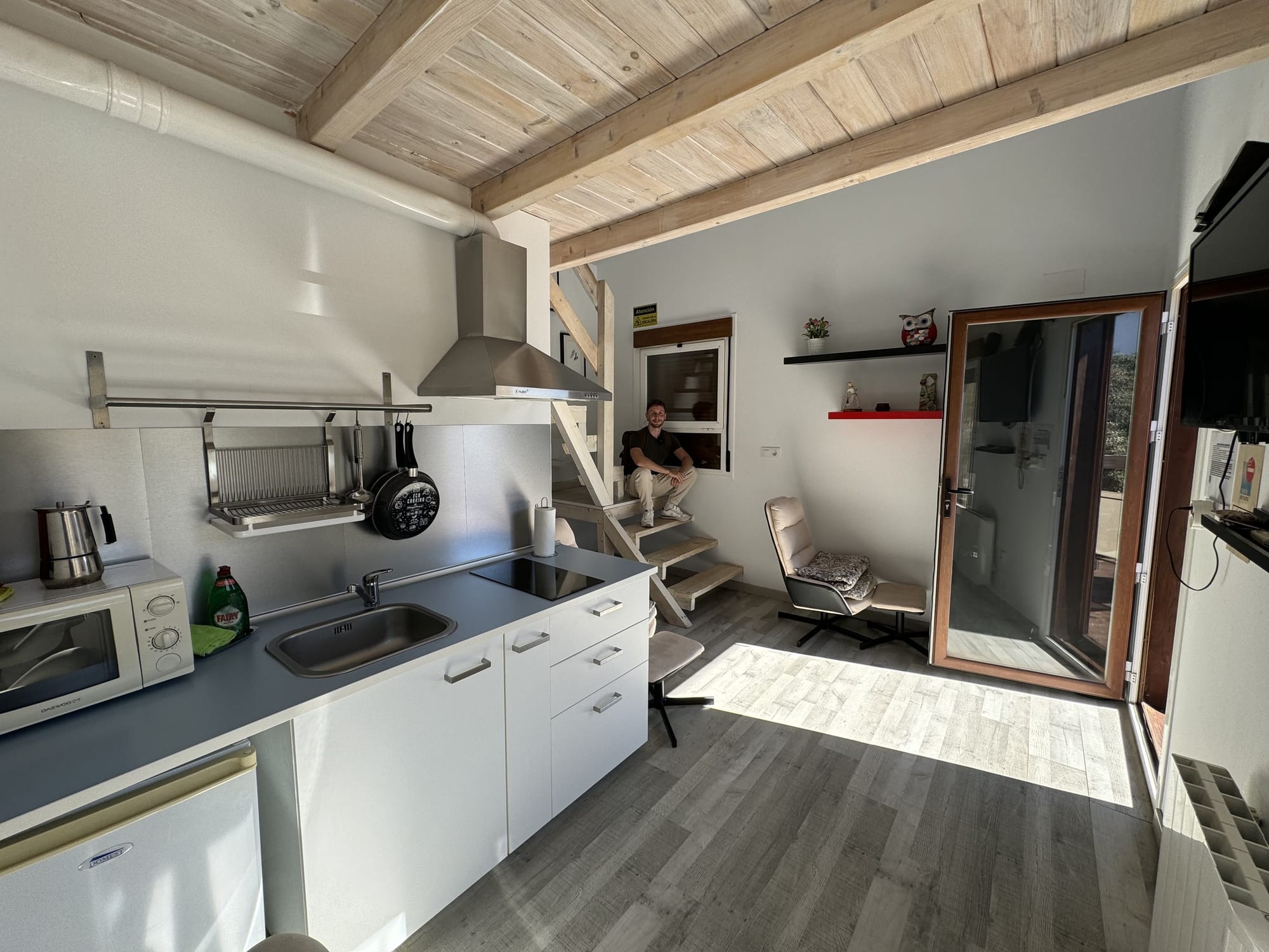 Cocina y salón de la cabaña con techo de madera en Cabaña el Valle