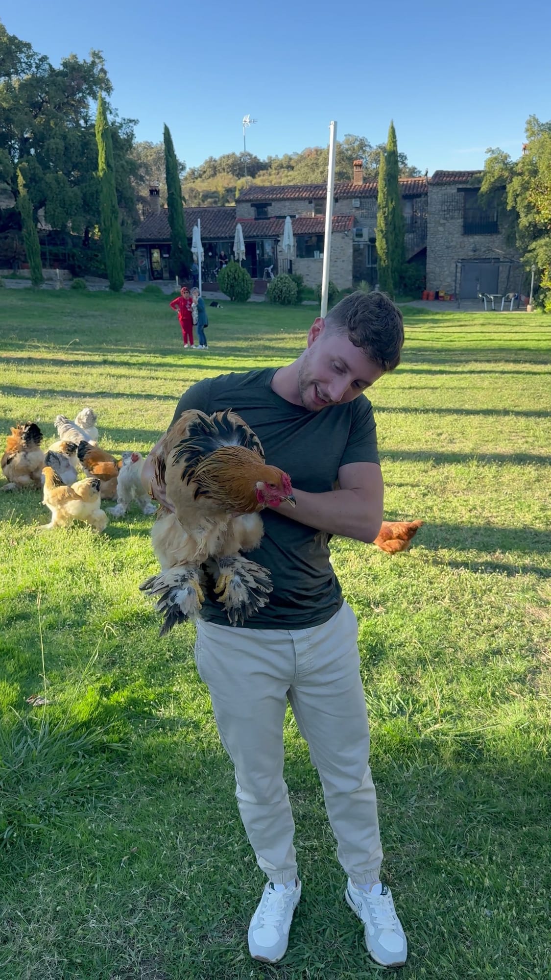 Javier Sobrino con una gallina en brazos en el jardín de Cabaña el Valle