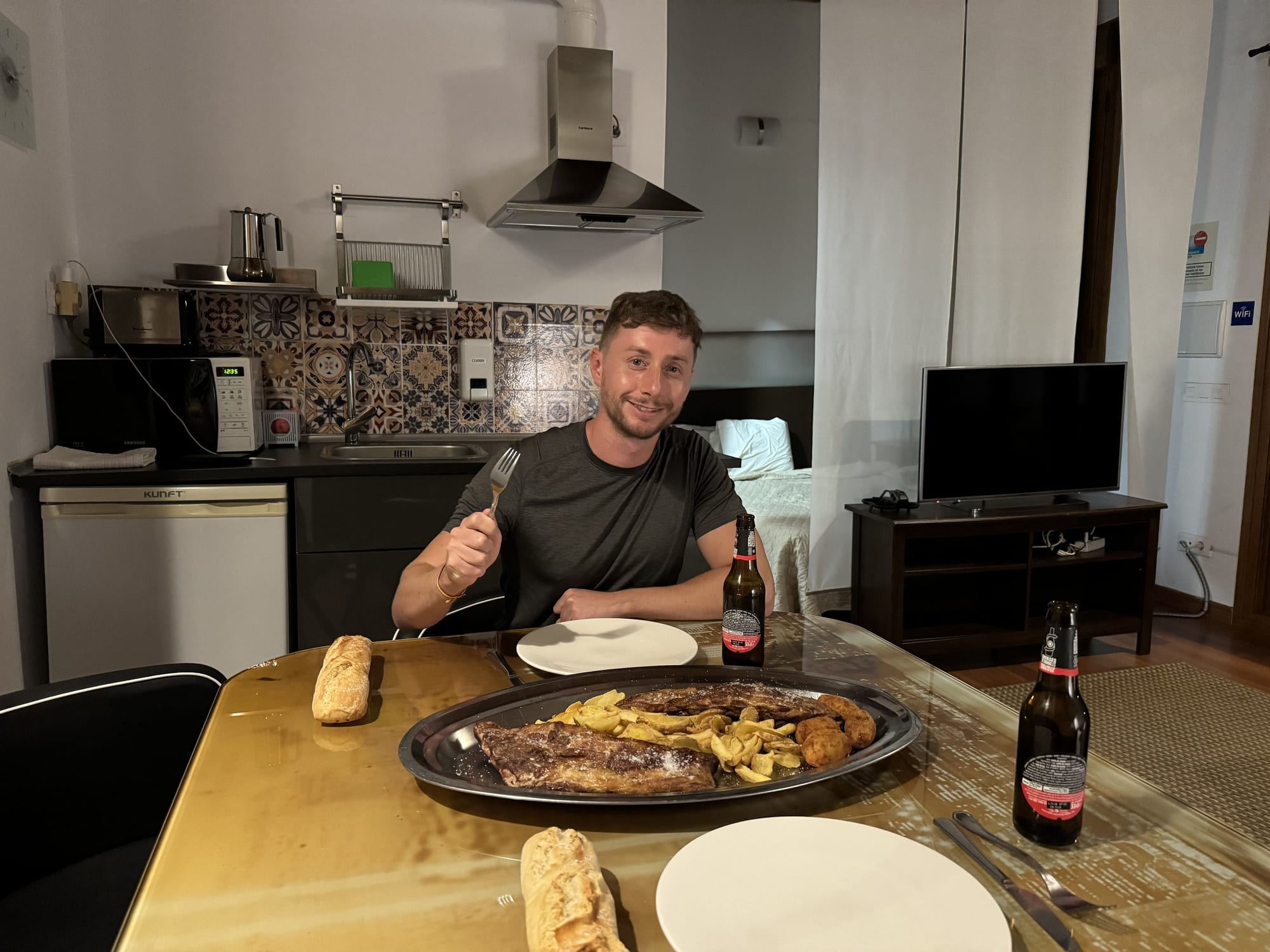 Javier Sobrino cenando chuletón con patatas en la cocina de la cabaña de Cabaña el Valle