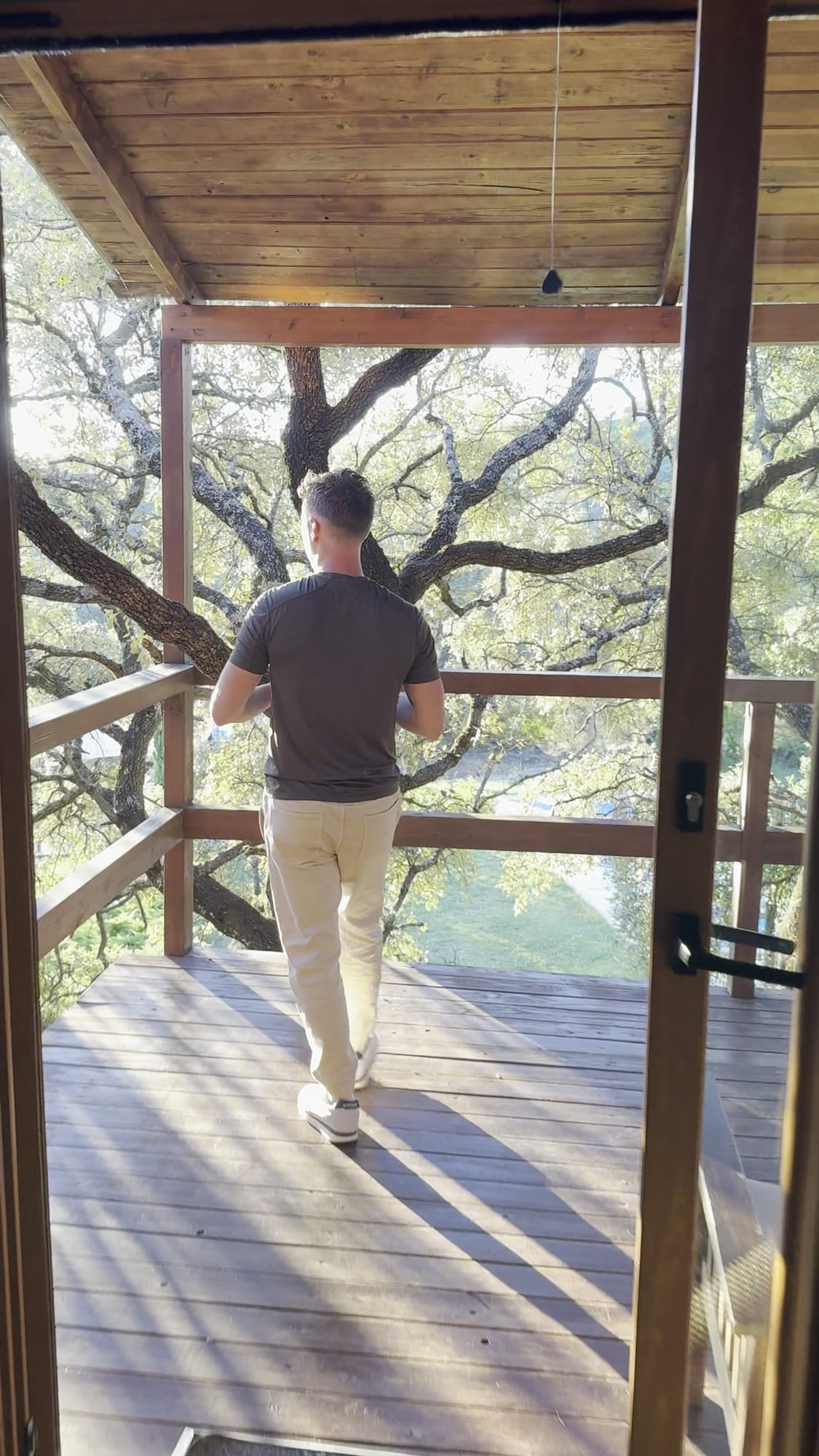 Terraza de madera de la cabaña asomada a la encina en Cabaña el Valle