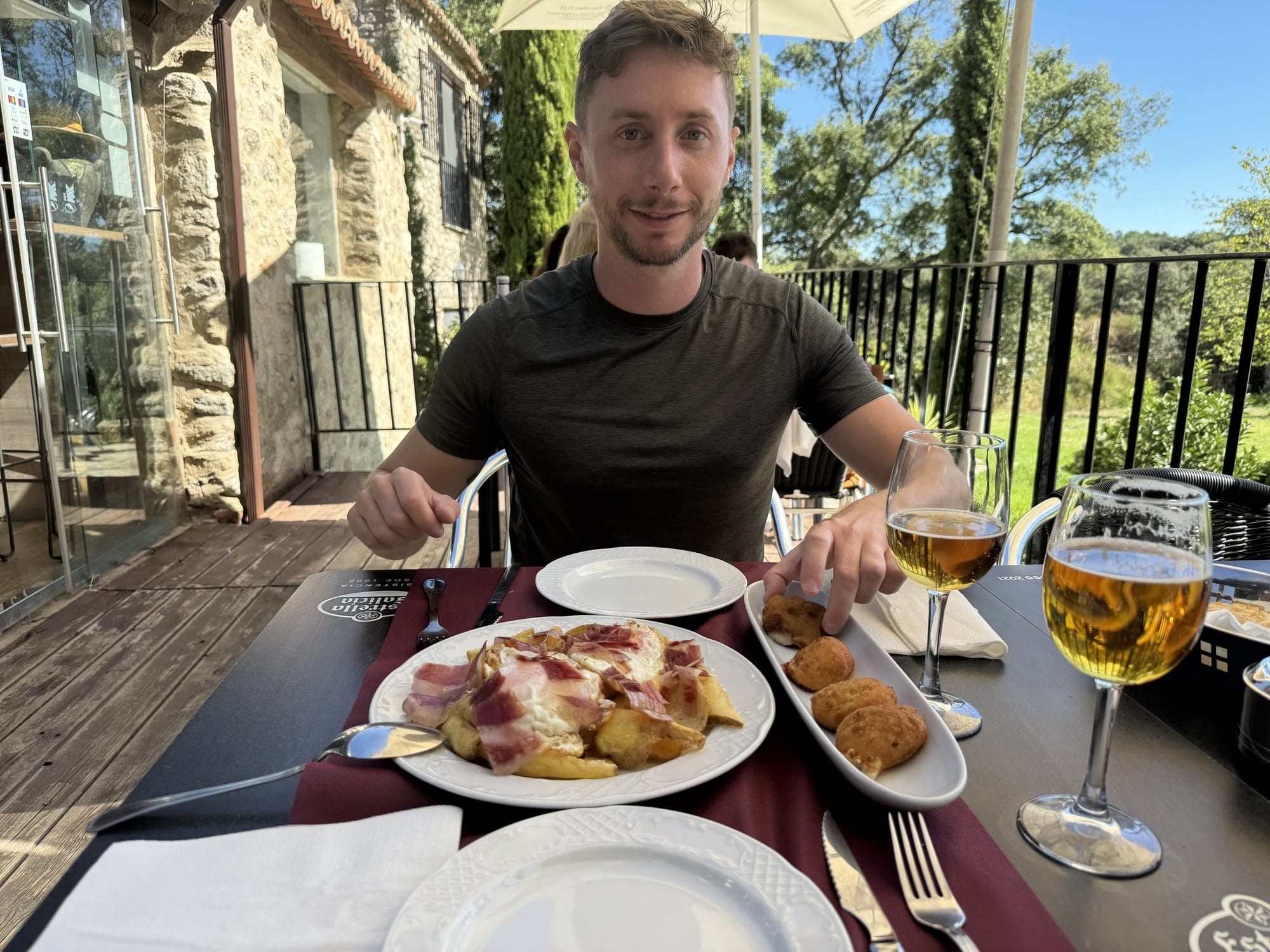 Huevos rotos con jamón, croquetas y cerveza en la terraza del restaurante de Cabaña el Valle