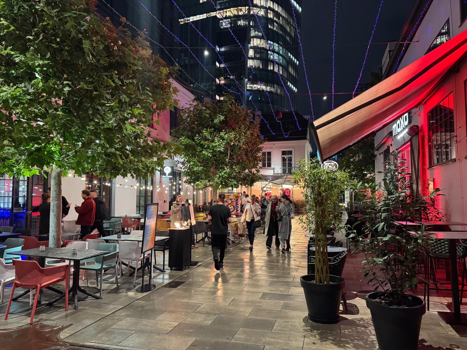 Calle peatonal de Varsovia con terrazas y luces de colores por la noche