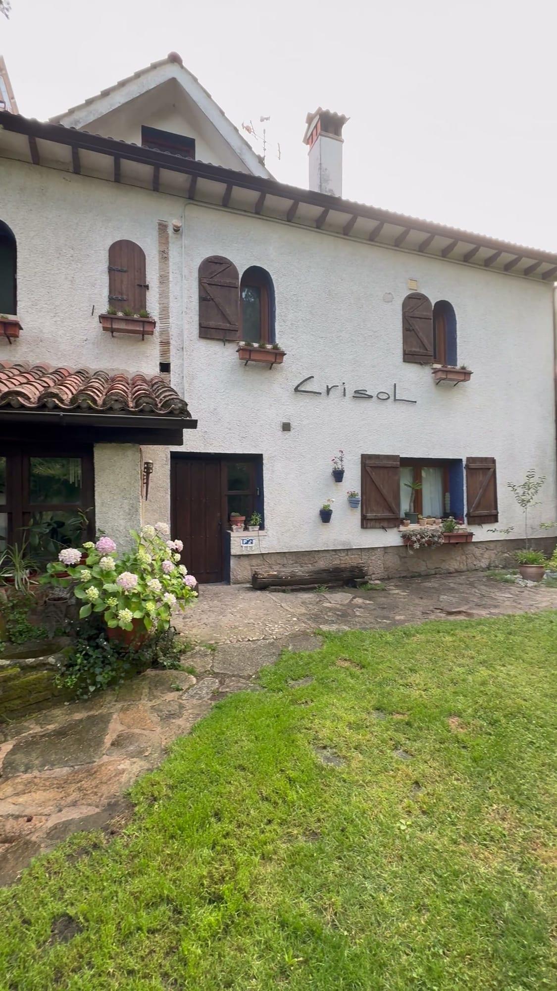 Fachada blanca con contraventanas de madera de la casa principal de Cabañas Crisol