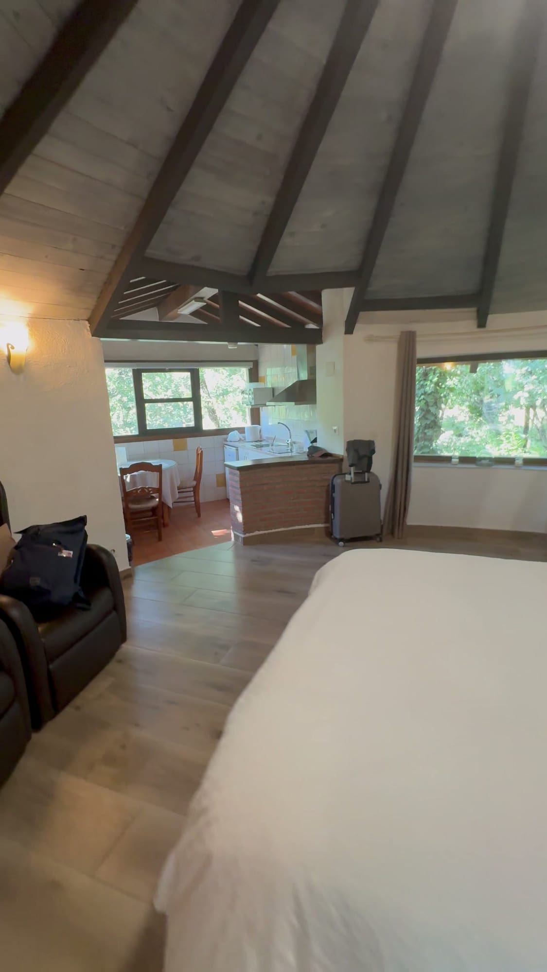 Interior de una cabaña redonda de Cabañas Crisol con cama, cocina y techo de vigas