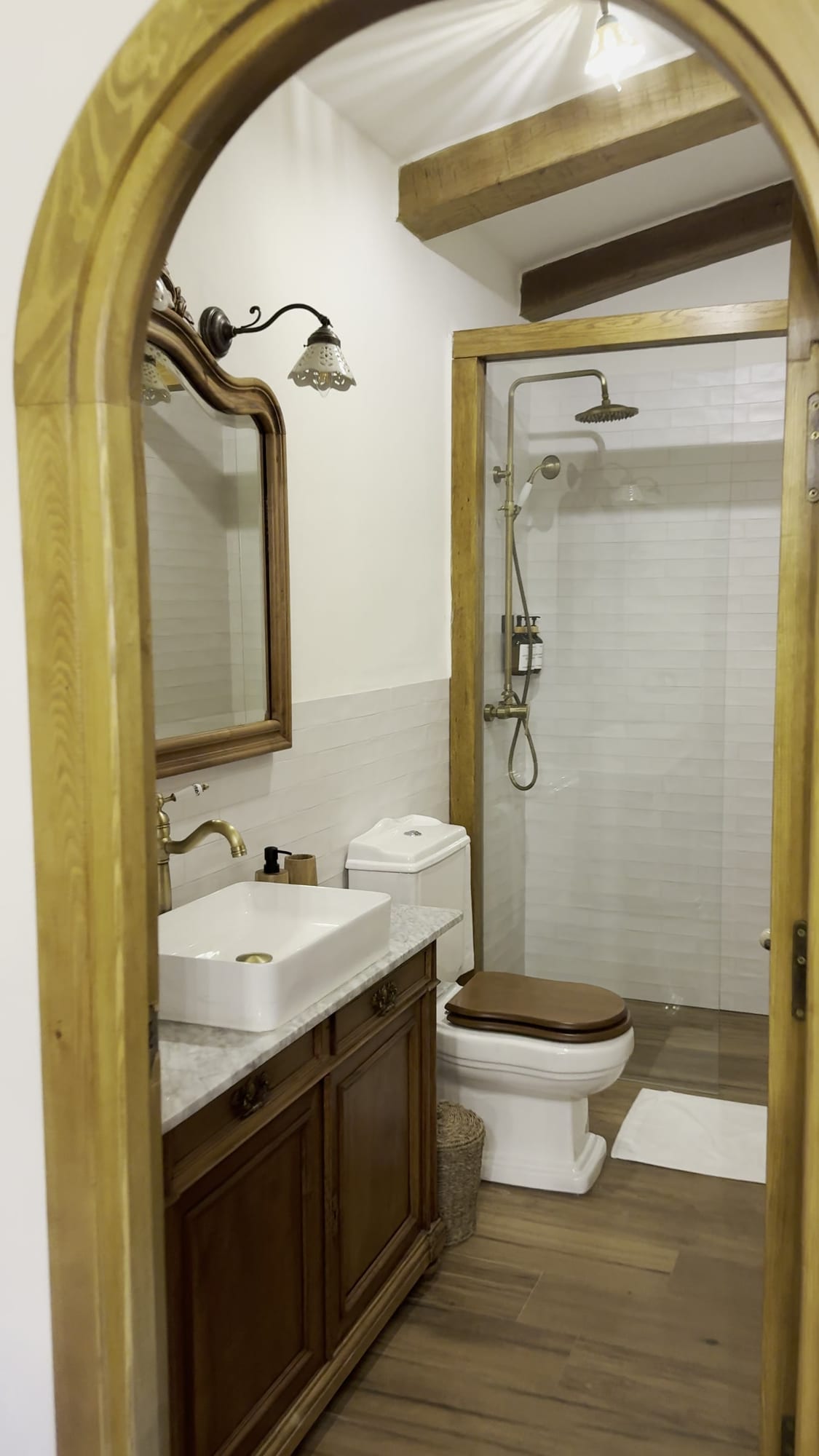 Baño con ducha y lavabo visto por la puerta en arco de la casita de La Comarca de Veratton