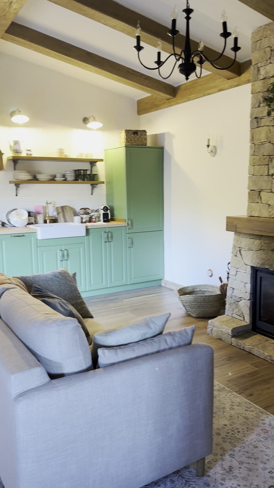 Sofá y cocina verde de la casita de La Comarca de Veratton