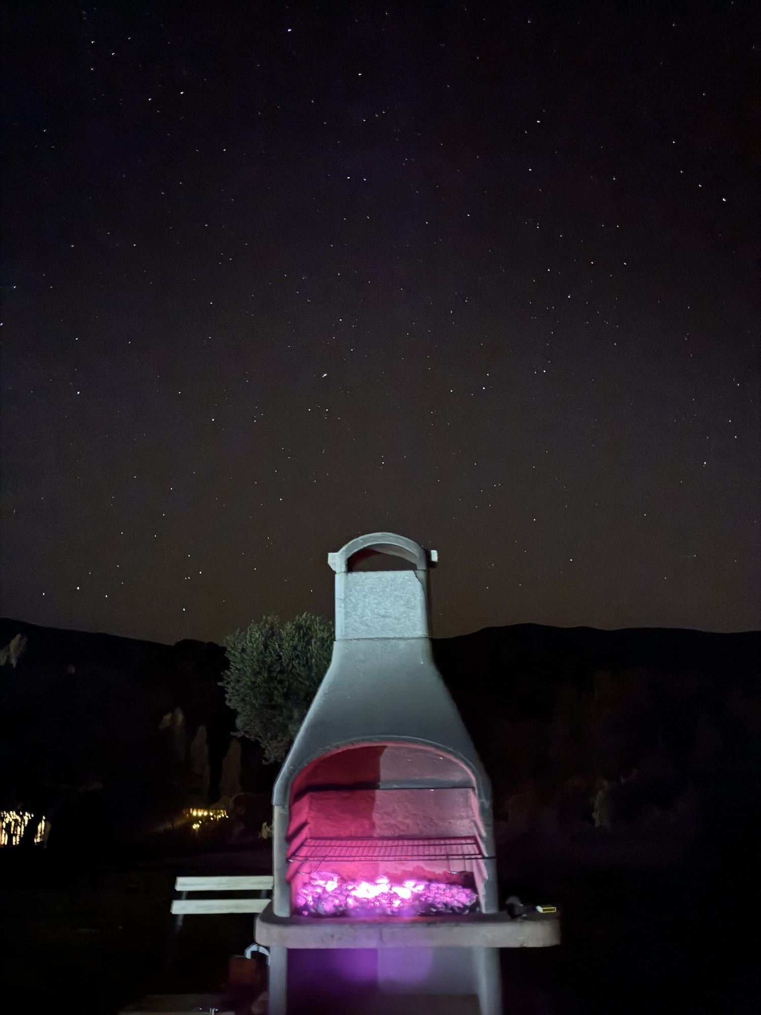 Barbacoa de obra encendida bajo un cielo lleno de estrellas en Cork Valley