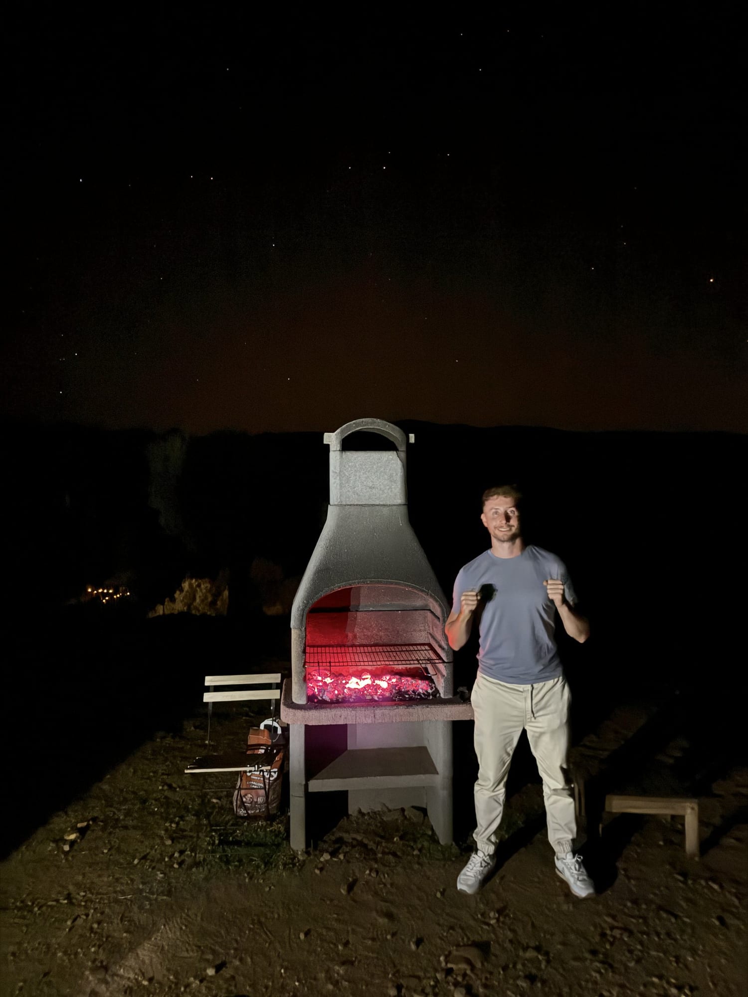 Javier Sobrino junto a la barbacoa encendida por la noche en Cork Valley