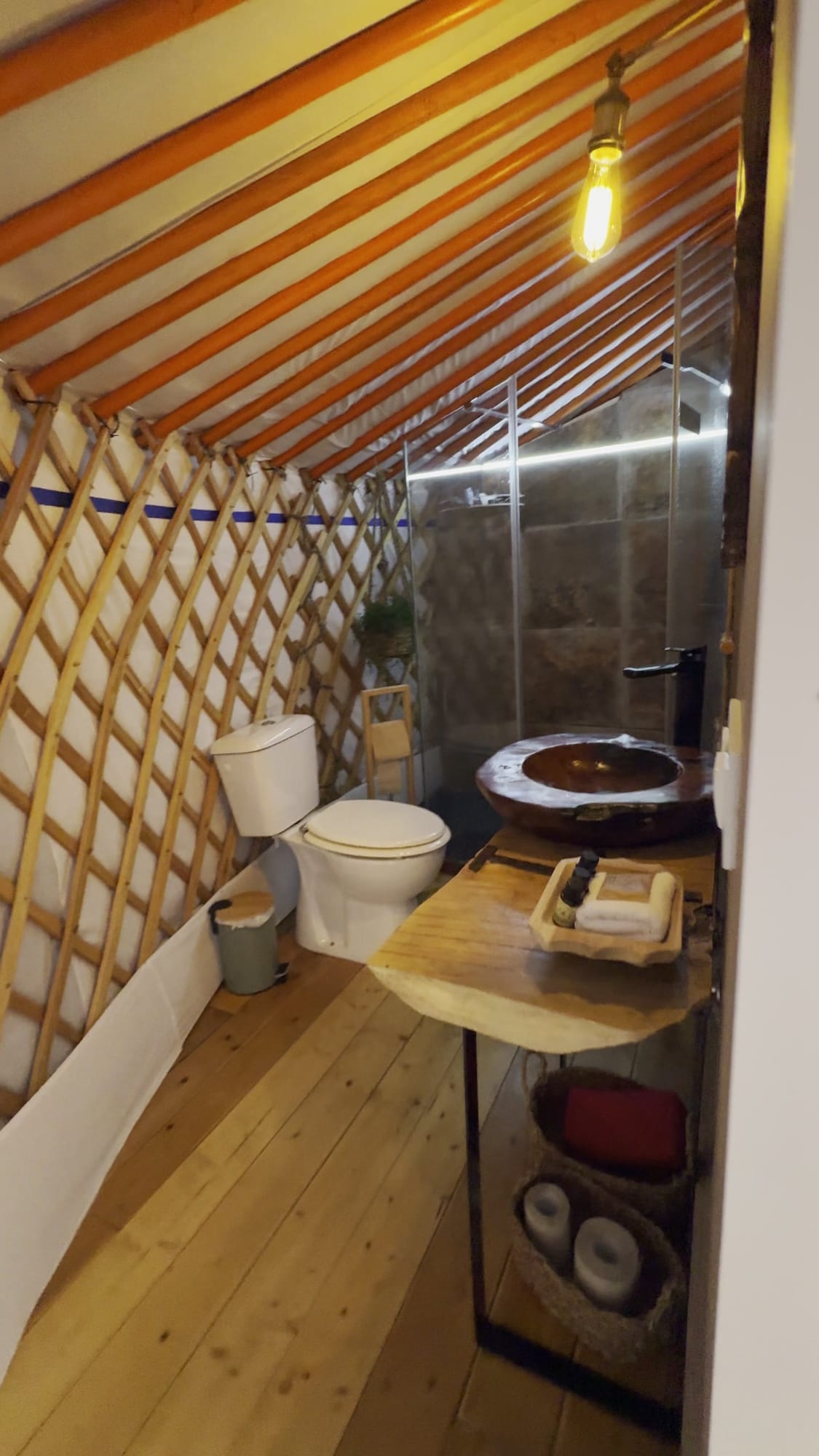 Baño con ducha y lavabo de madera dentro de una yurta de El Jardín de las Delizias