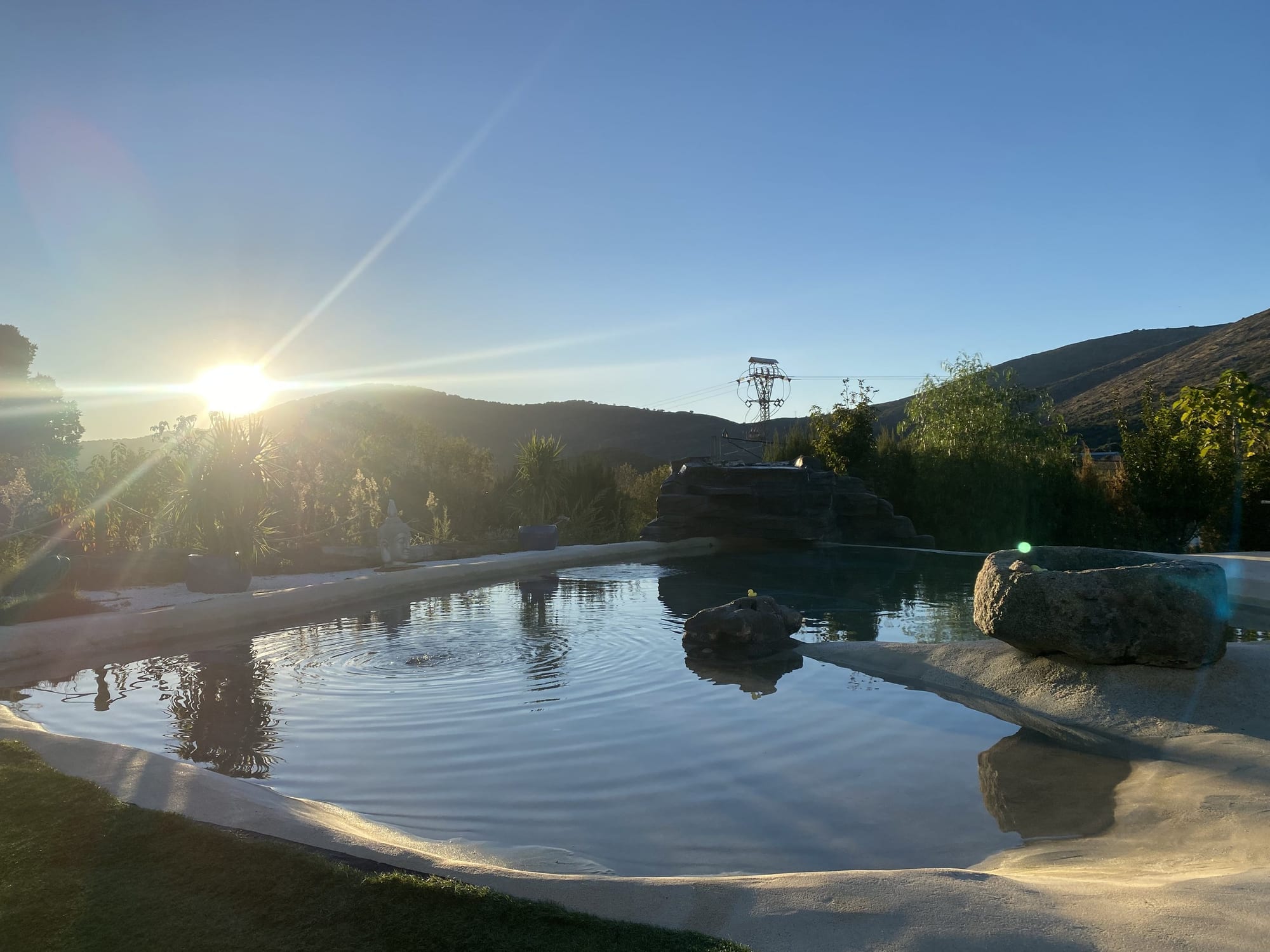 Piscina de agua salada de estilo natural al atardecer en El Jardín de las Delizias