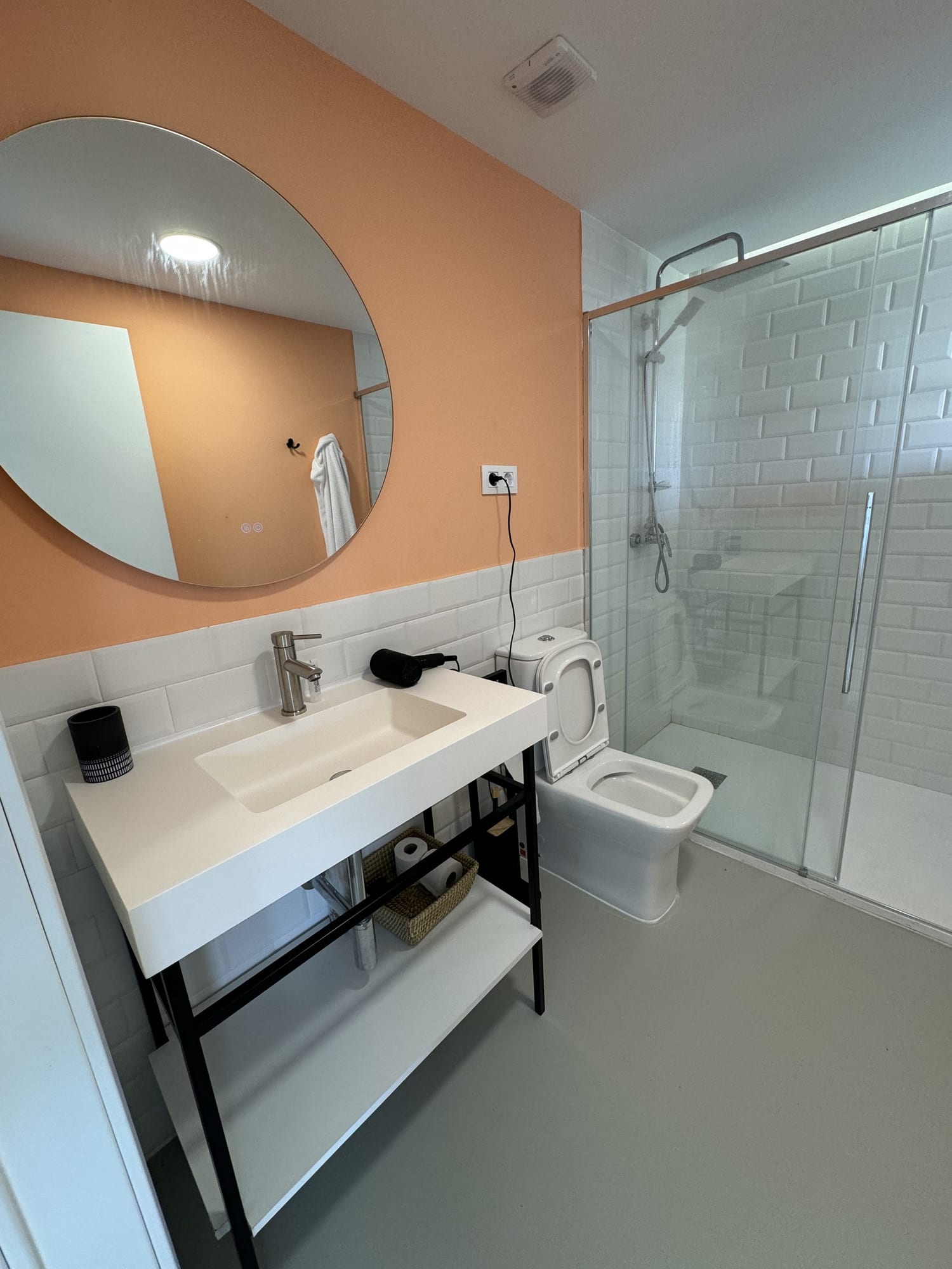 Baño con espejo redondo, lavabo y ducha de cristal en Estrellas de Gredos