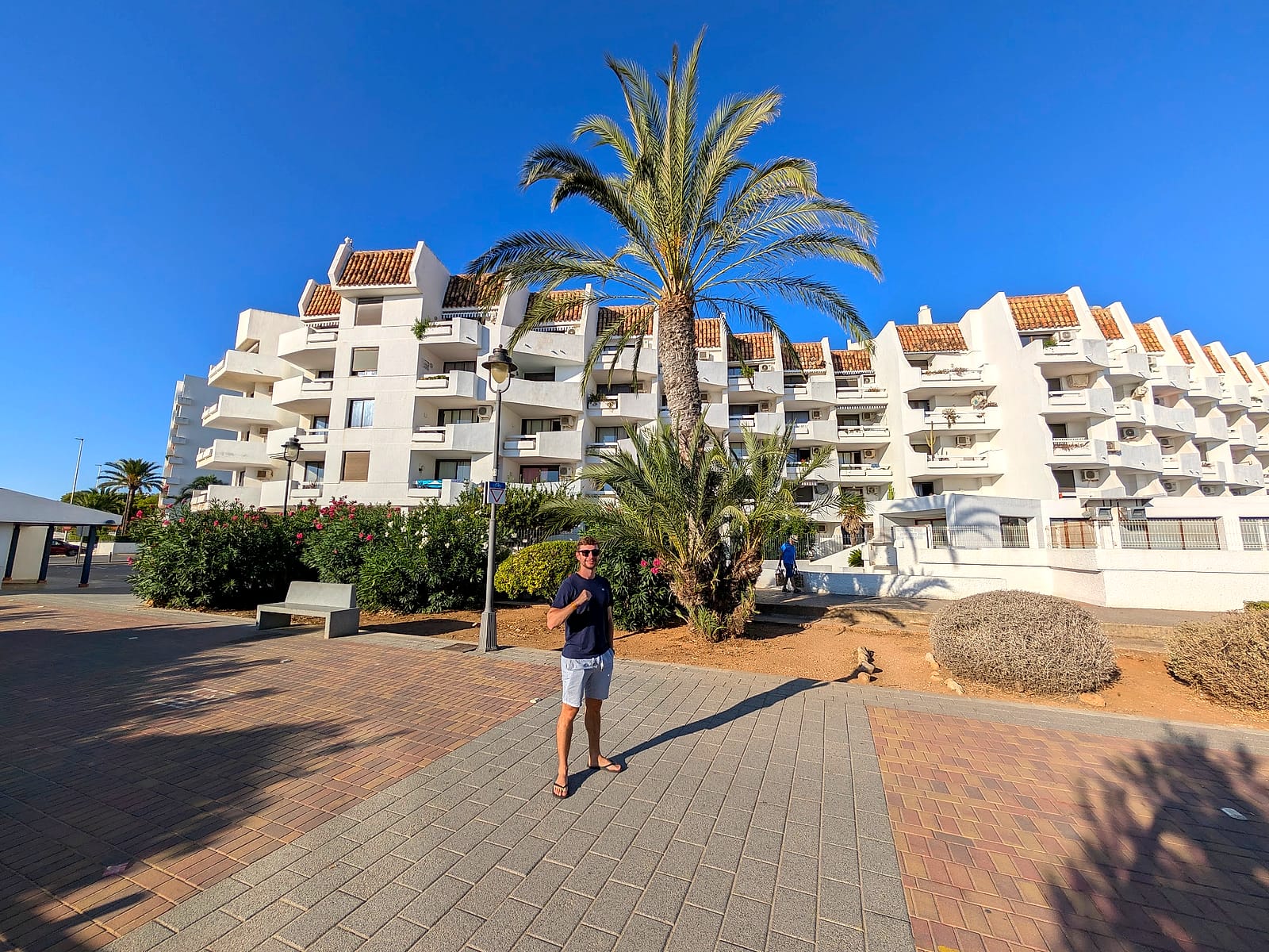 Javier Sobrino delante de la fachada blanca y escalonada del Eurhostal, con una palmera