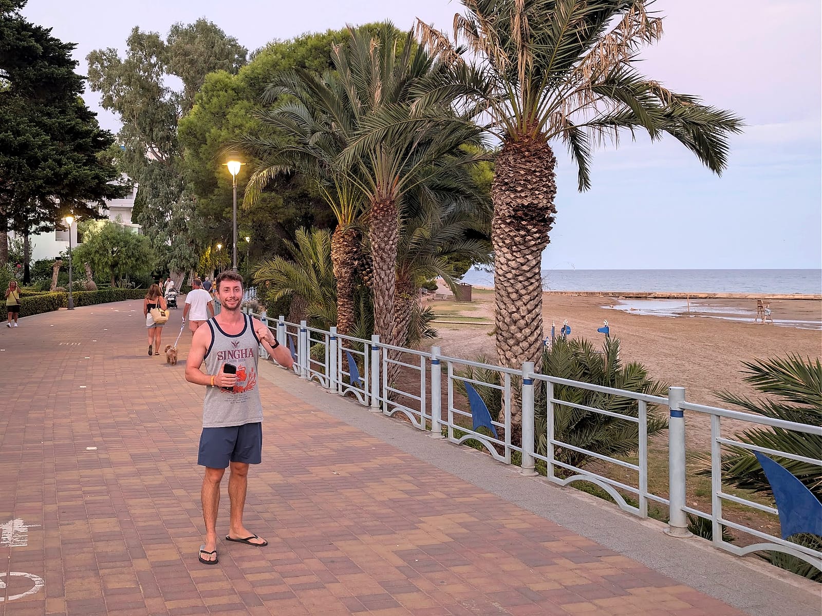 Javier Sobrino en el paseo marítimo de Alcossebre al atardecer, con palmeras y la playa al lado