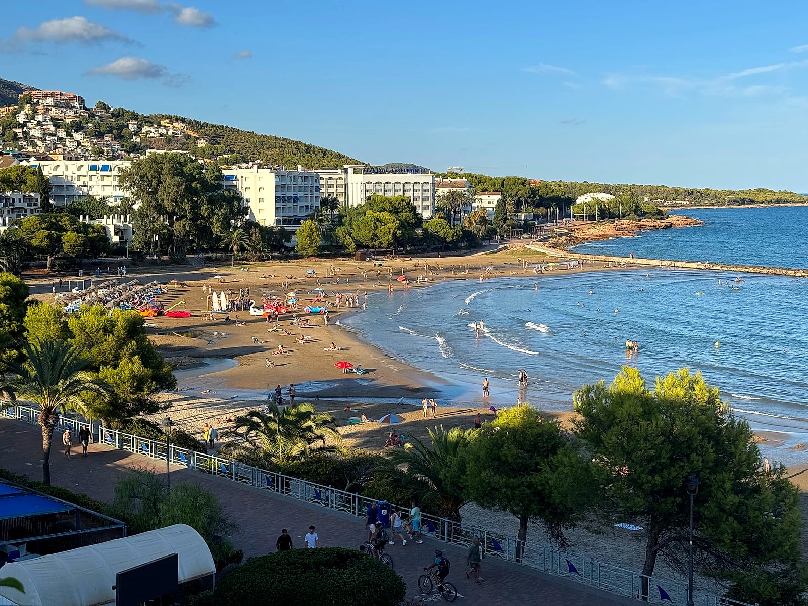 La playa de las Fuentes, en Alcossebre, vista desde un apartamento del Eurhostal, con bañistas y el paseo marítimo