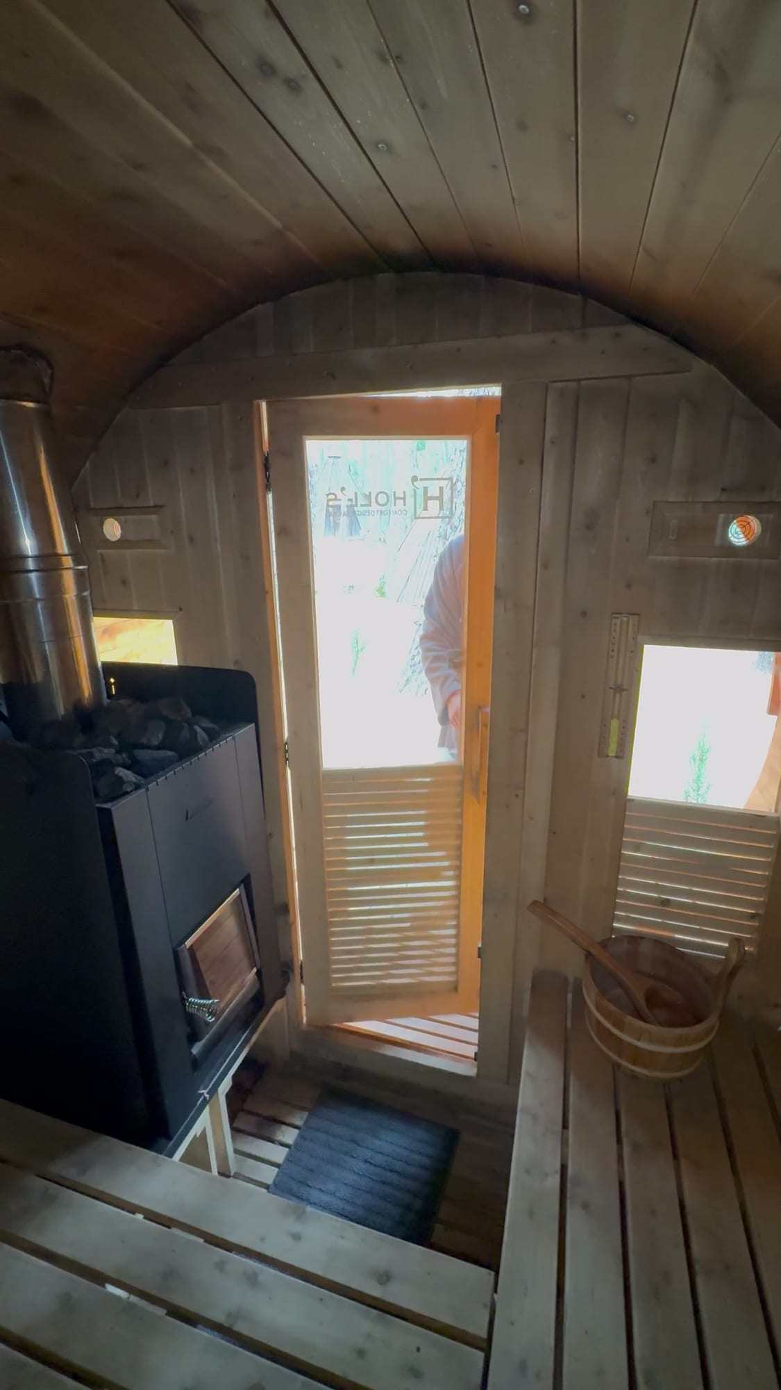 Interior de la sauna de barril con estufa de leña en el Glamping The Teepee