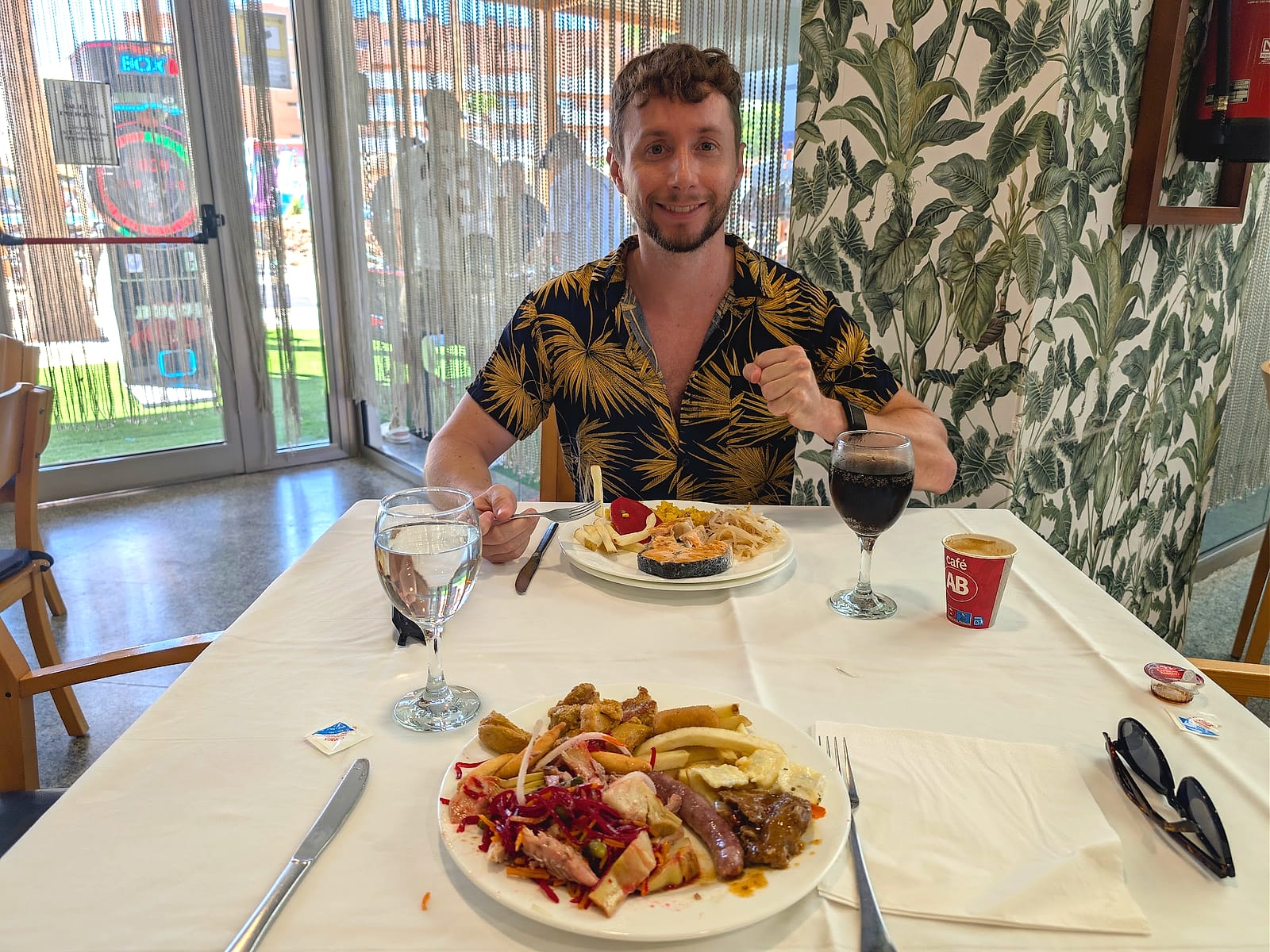 Javier Sobrino comiendo en el buffet del Hotel Neptuno, con un plato variado y una copa de vino