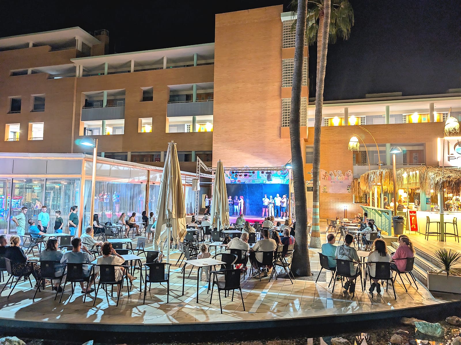 La animación de noche en el escenario del Hotel Neptuno, con clientes en las mesas