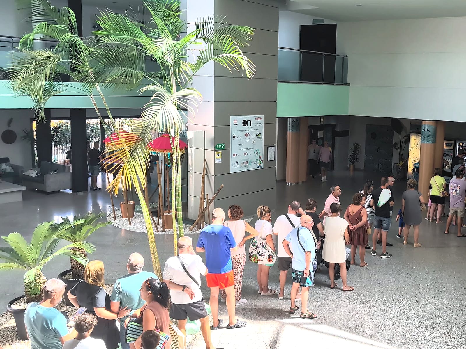 Clientes haciendo cola en el vestíbulo del Hotel Neptuno para entrar al buffet del almuerzo