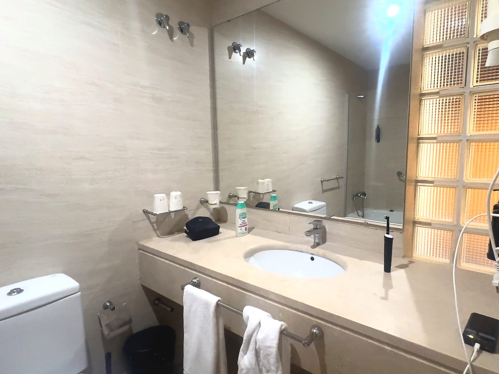 El lavabo del baño del Hotel Neptuno, con una encimera larga y un espejo grande