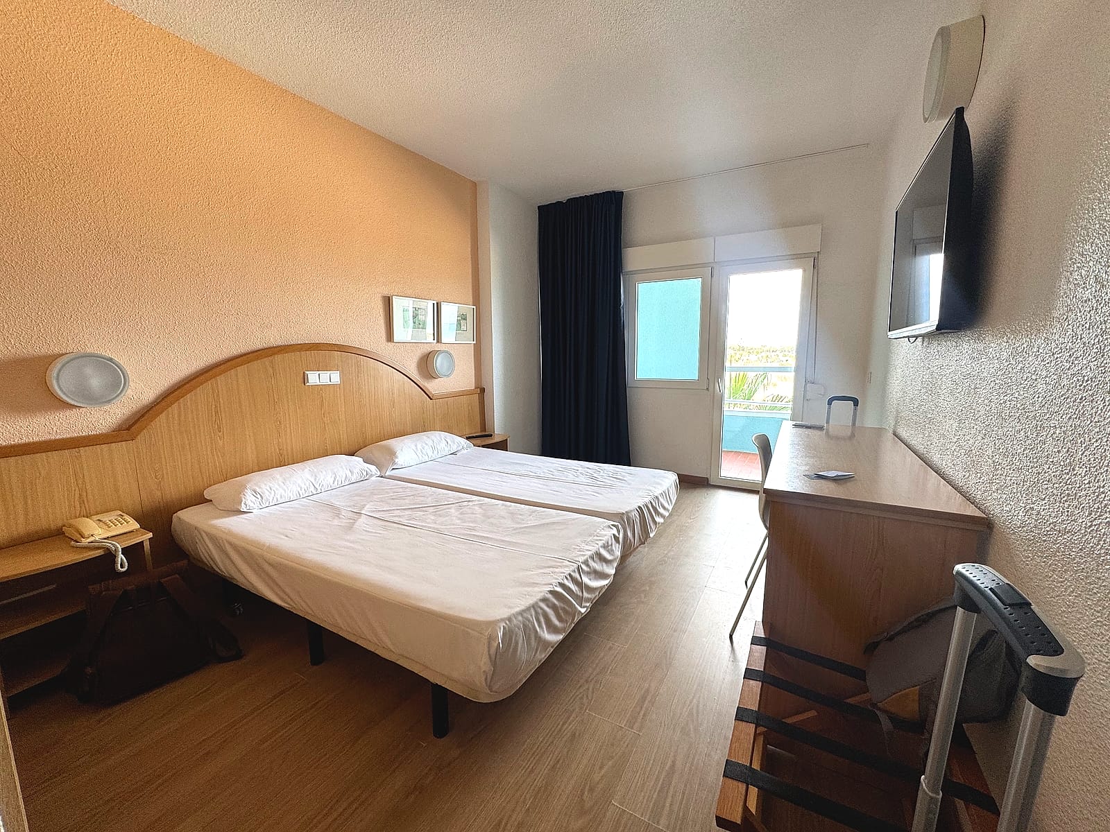 Habitación estándar del Hotel Playas de Guardamar, con las camas, la televisión en la pared y la salida a la terraza
