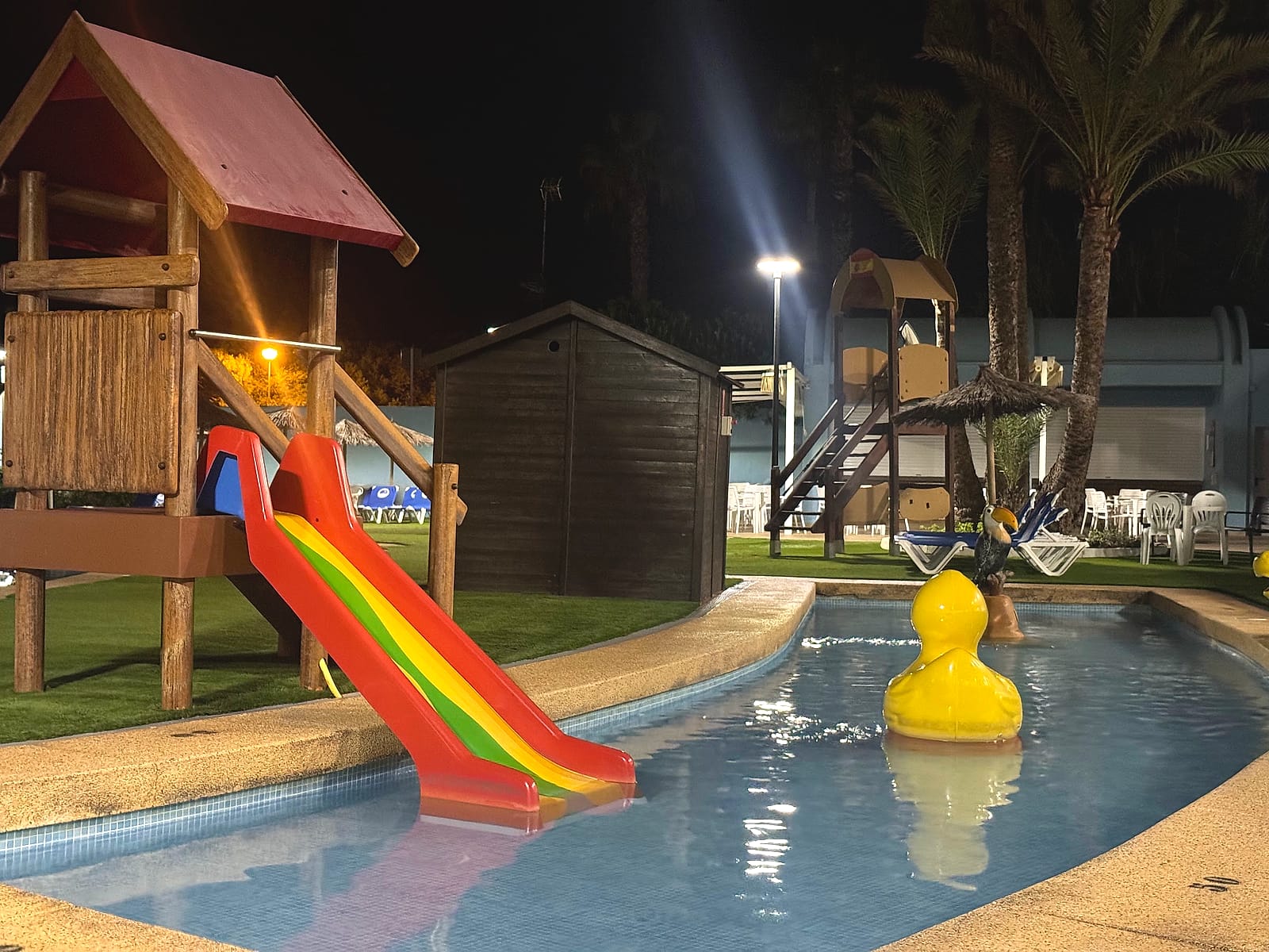 La piscina infantil del Hotel Playas de Guardamar de noche, con su tobogán de colores y un pato gigante