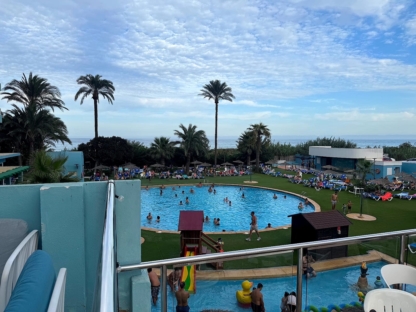 Las piscinas del Hotel Playas de Guardamar vistas desde una terraza, con la infantil, el parque y las palmeras