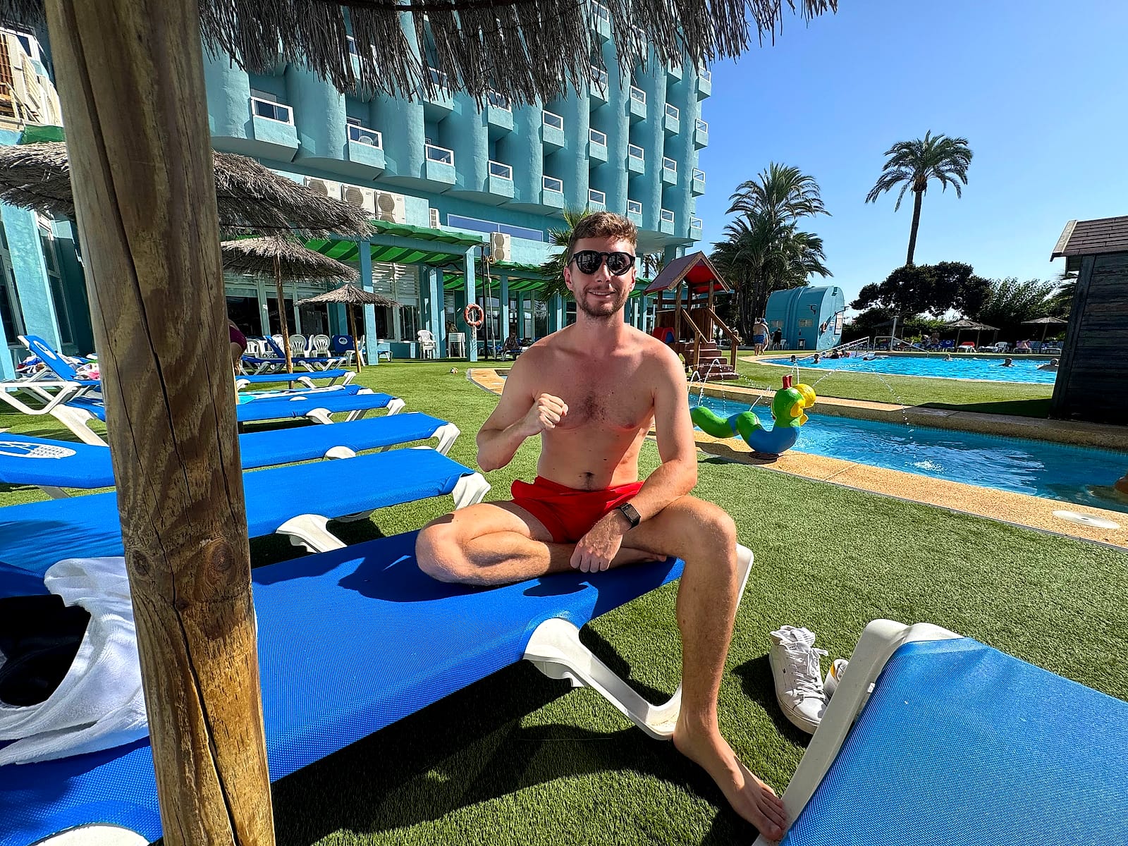 Javier Sobrino en una tumbona del Hotel Playas de Guardamar, con la piscina infantil y sus figuras de colores detrás