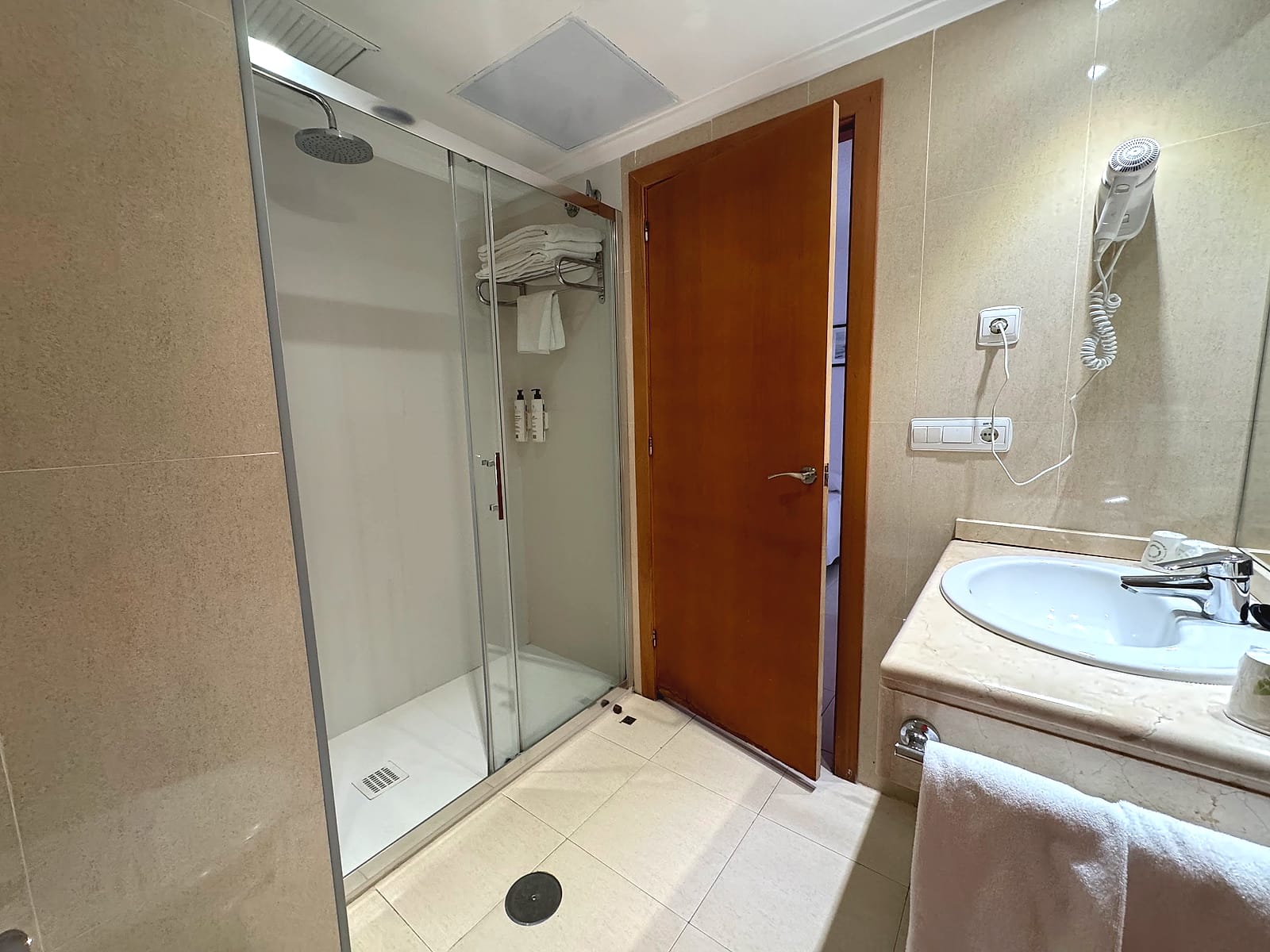 El baño de la habitación del Hotel Playas de Torrevieja, con ducha amplia de mampara y paredes de mármol