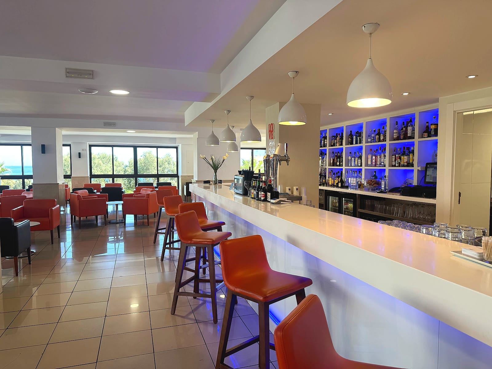 El bar cafetería del Hotel Playas de Torrevieja, con barra y taburetes naranjas