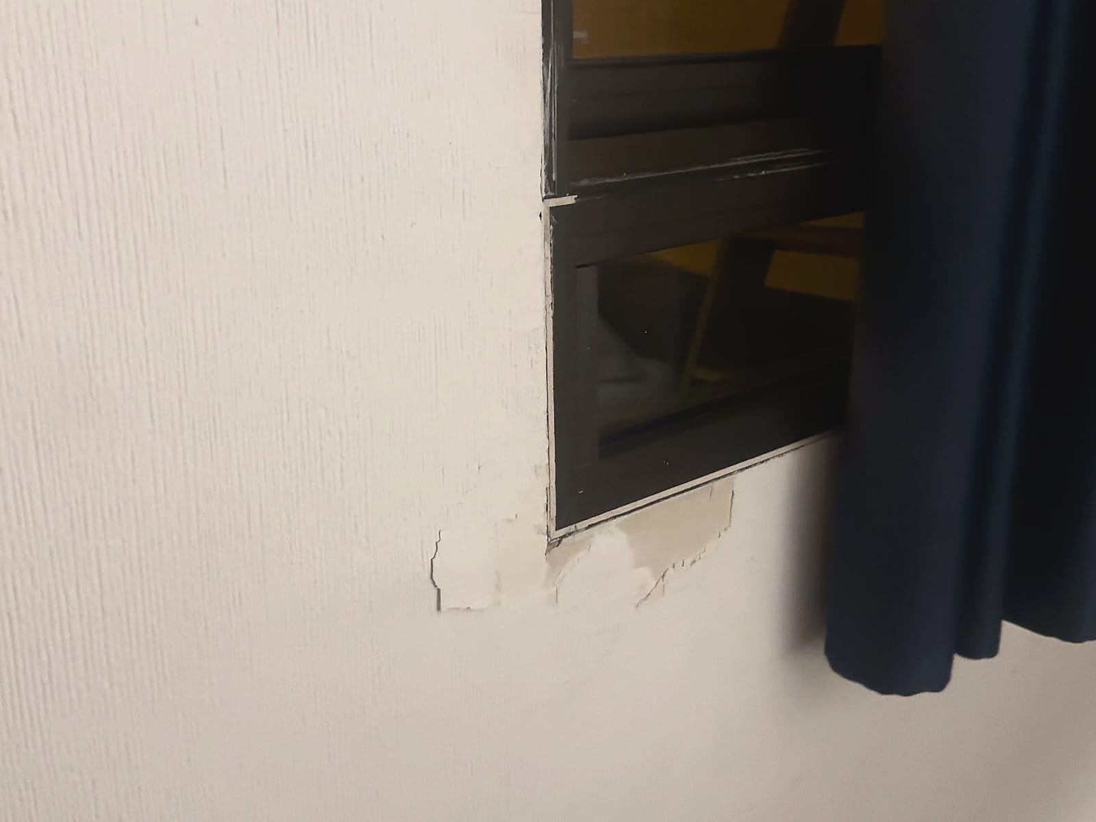Pared desconchada junto a la ventana en la habitación del Hotel Playas de Torrevieja