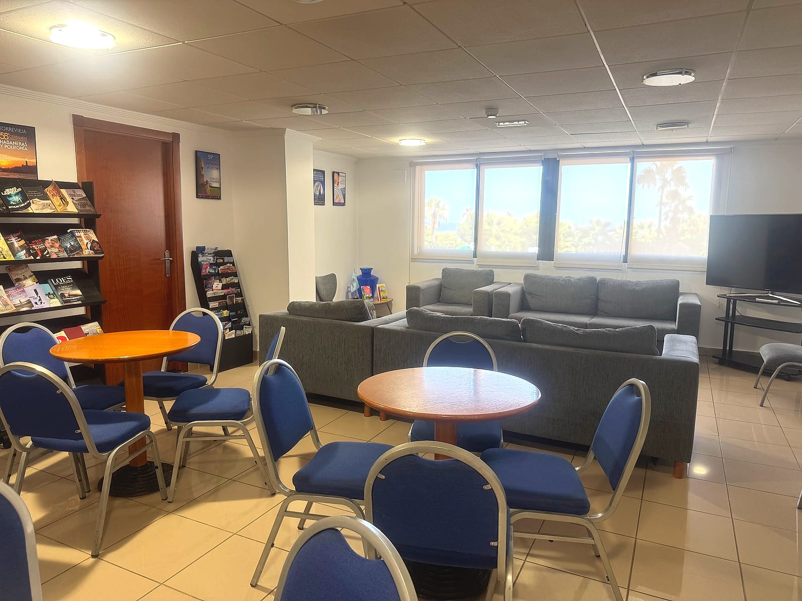 La sala de lectura del Hotel Playas de Torrevieja, con estantería de libros, sofás y mesas