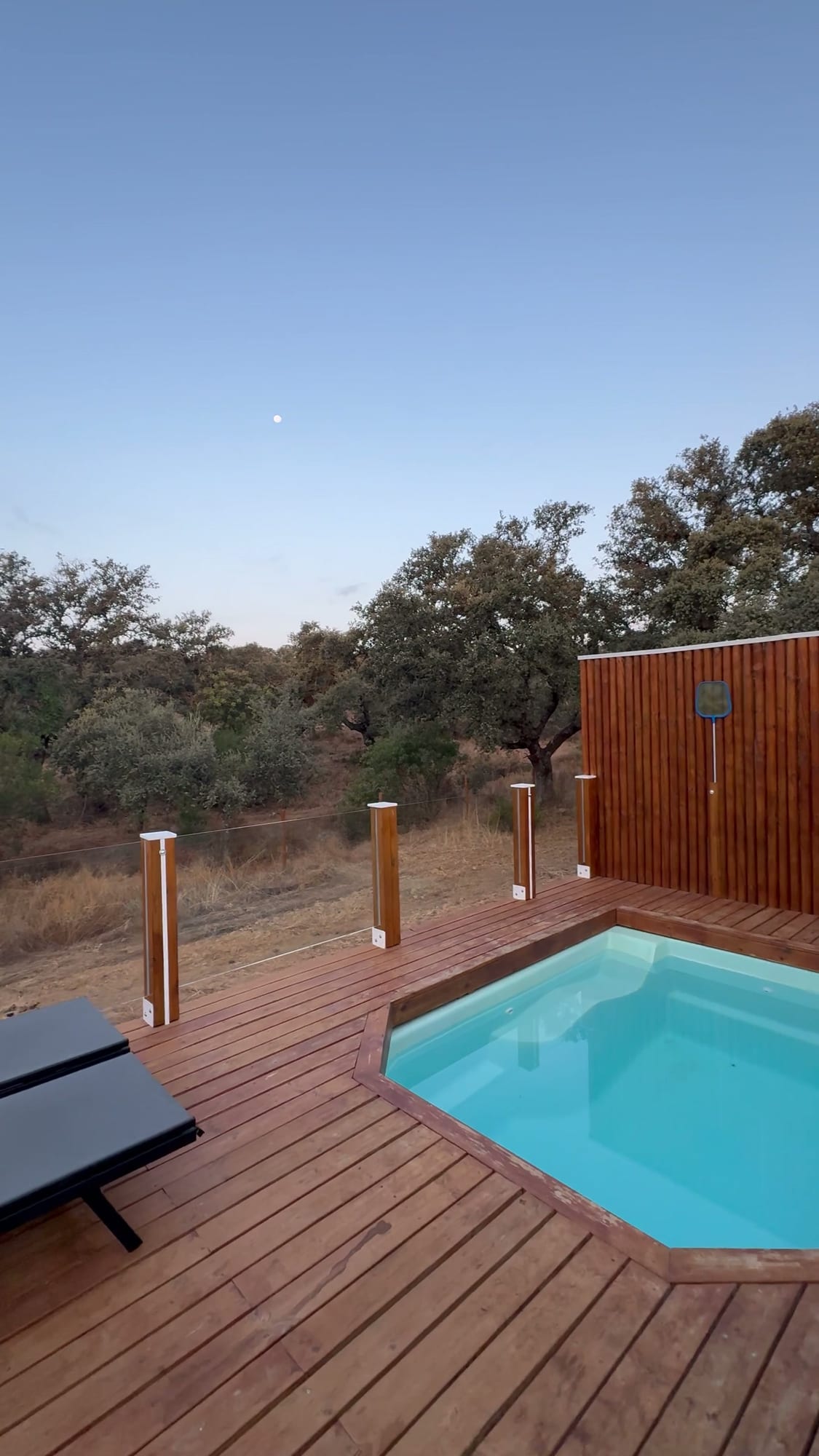 Piscina privada de la cápsula al amanecer entre encinas en La Dehesa Experiences