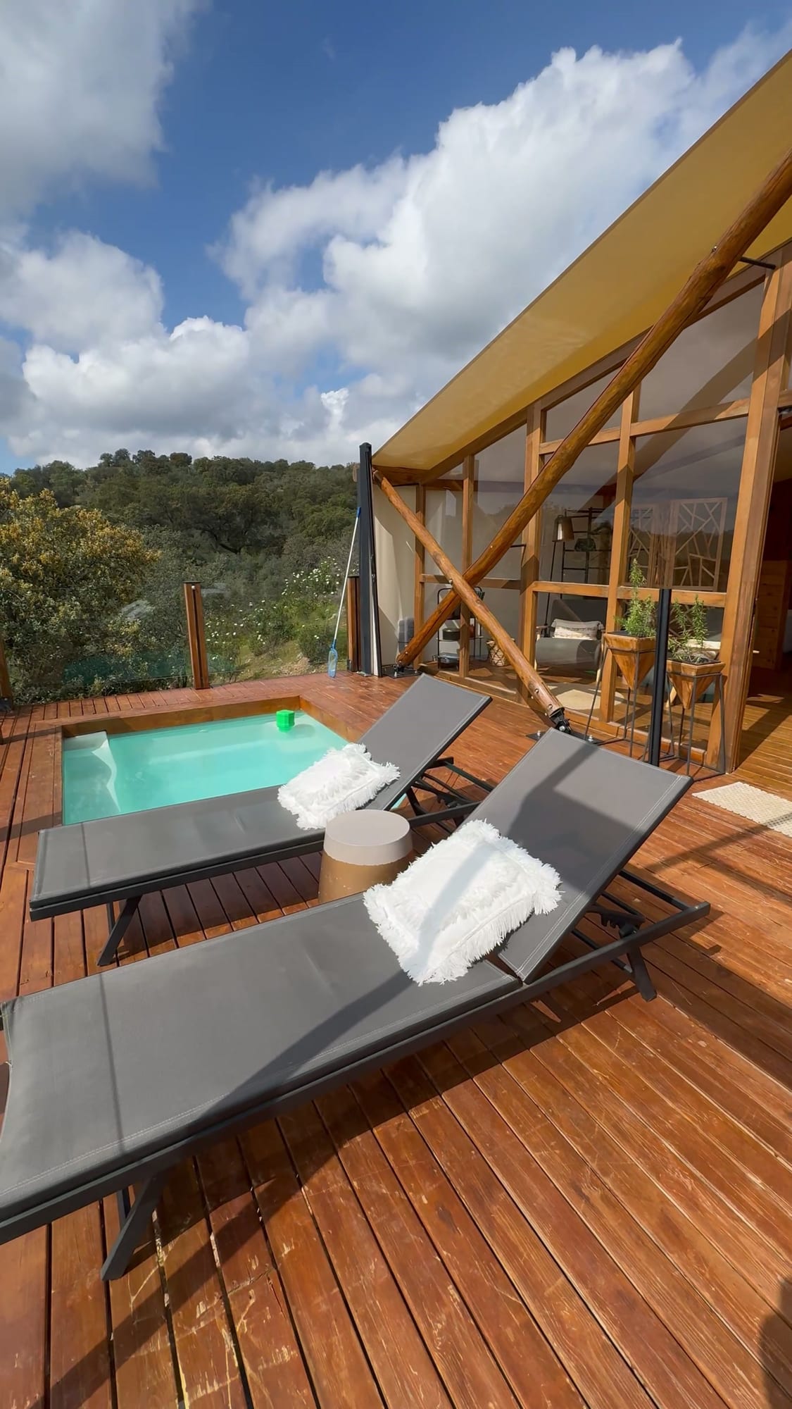 Piscina privada y hamacas en la terraza de una cabaña de La Dehesa Experiences, sobre la dehesa