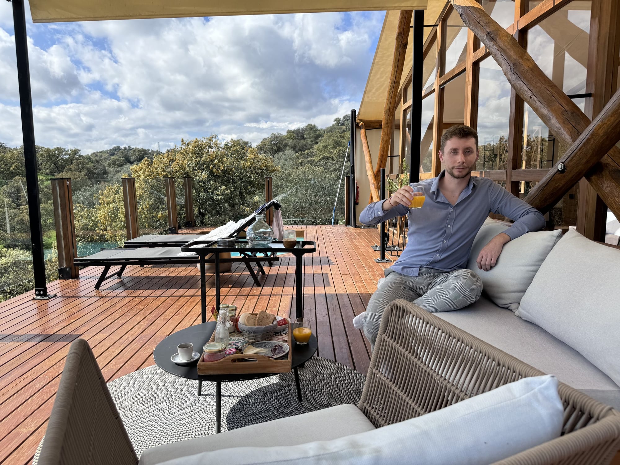 Javier Sobrino con un zumo en la terraza de la cabaña frente a la dehesa en La Dehesa Experiences