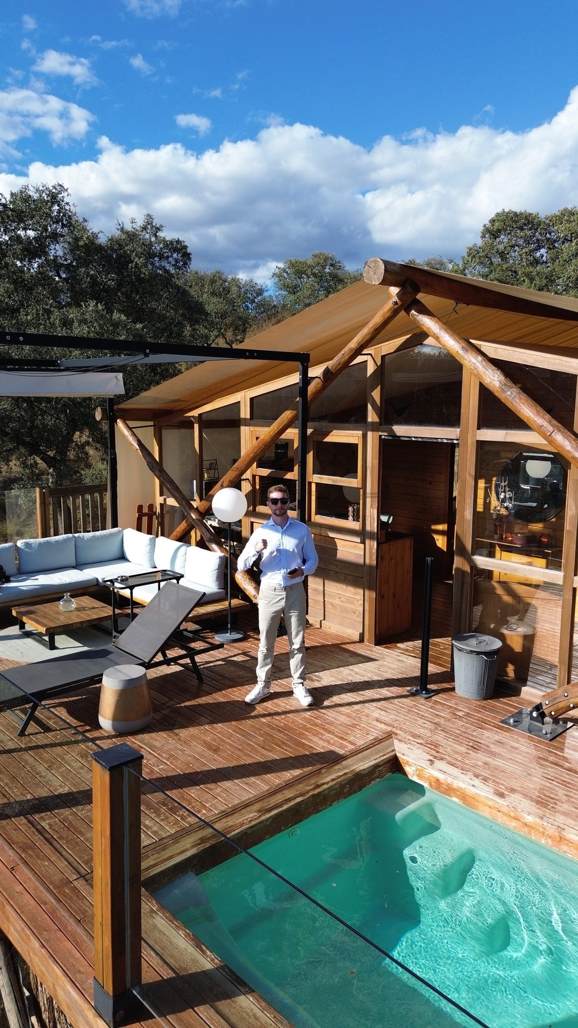 Javier Sobrino delante de su cabaña de madera con terraza y piscina privada en La Dehesa Experiences