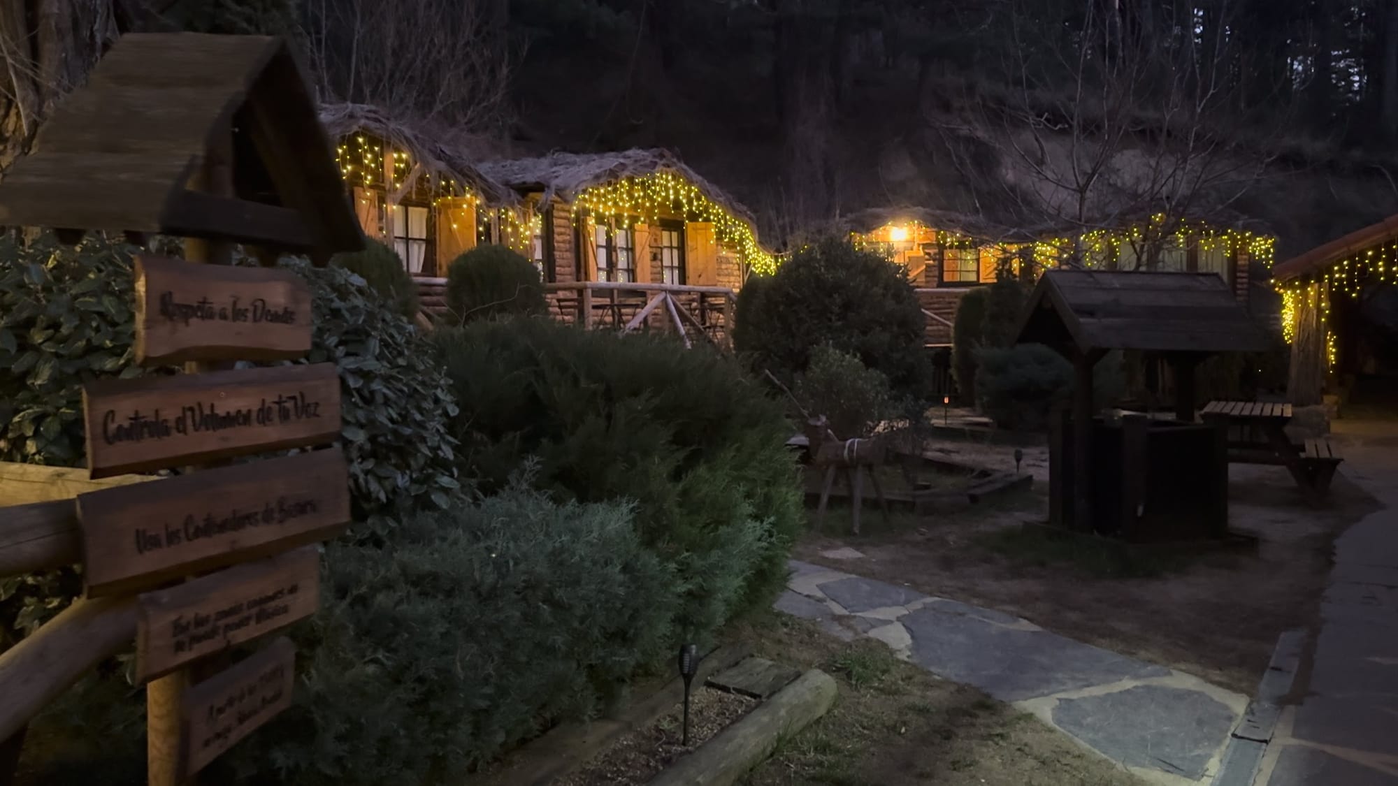 Cabañas de troncos de La Posada de Cercedilla iluminadas al anochecer