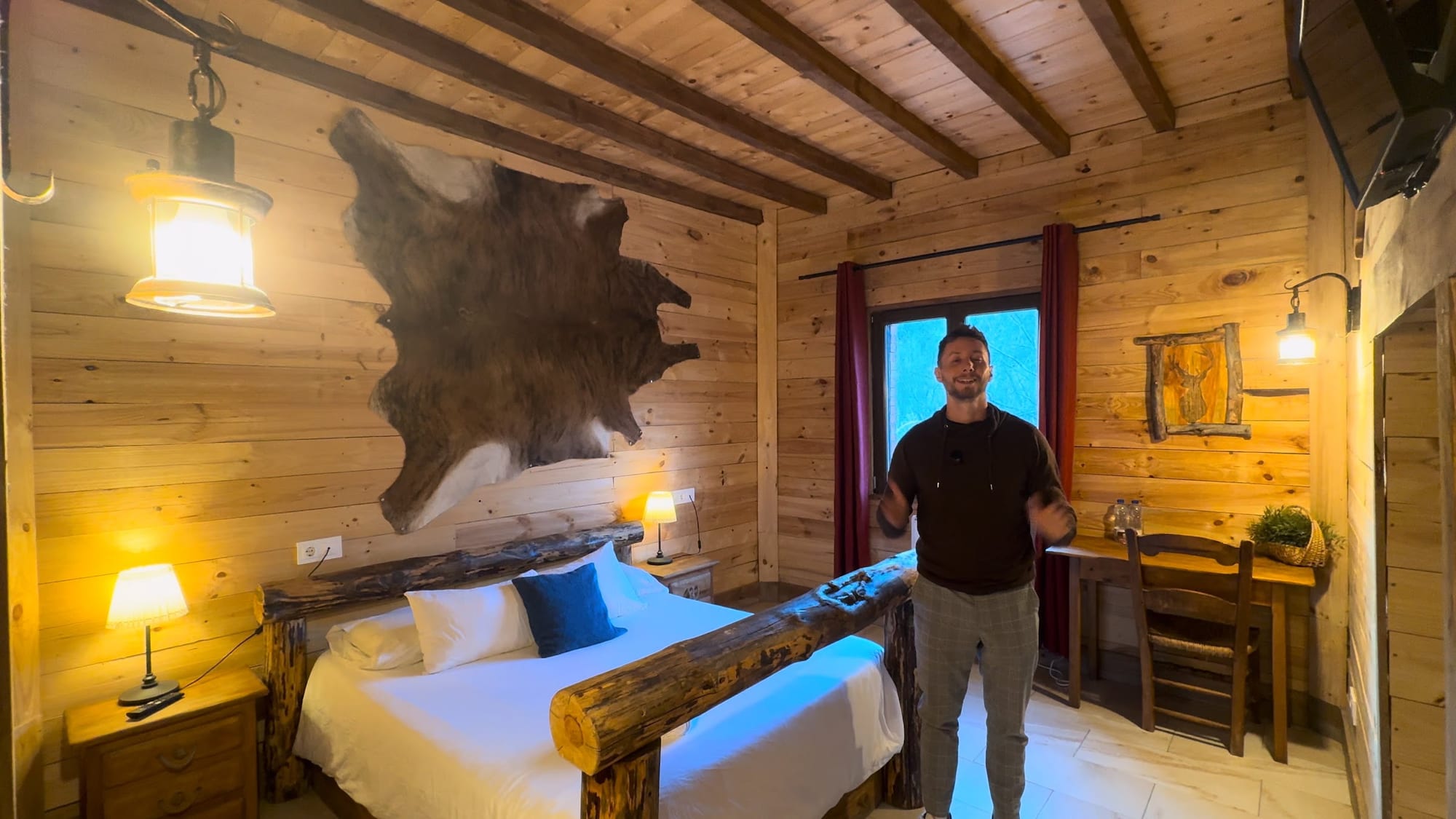 Javier Sobrino en la habitación de madera con cama de troncos de La Posada de Cercedilla