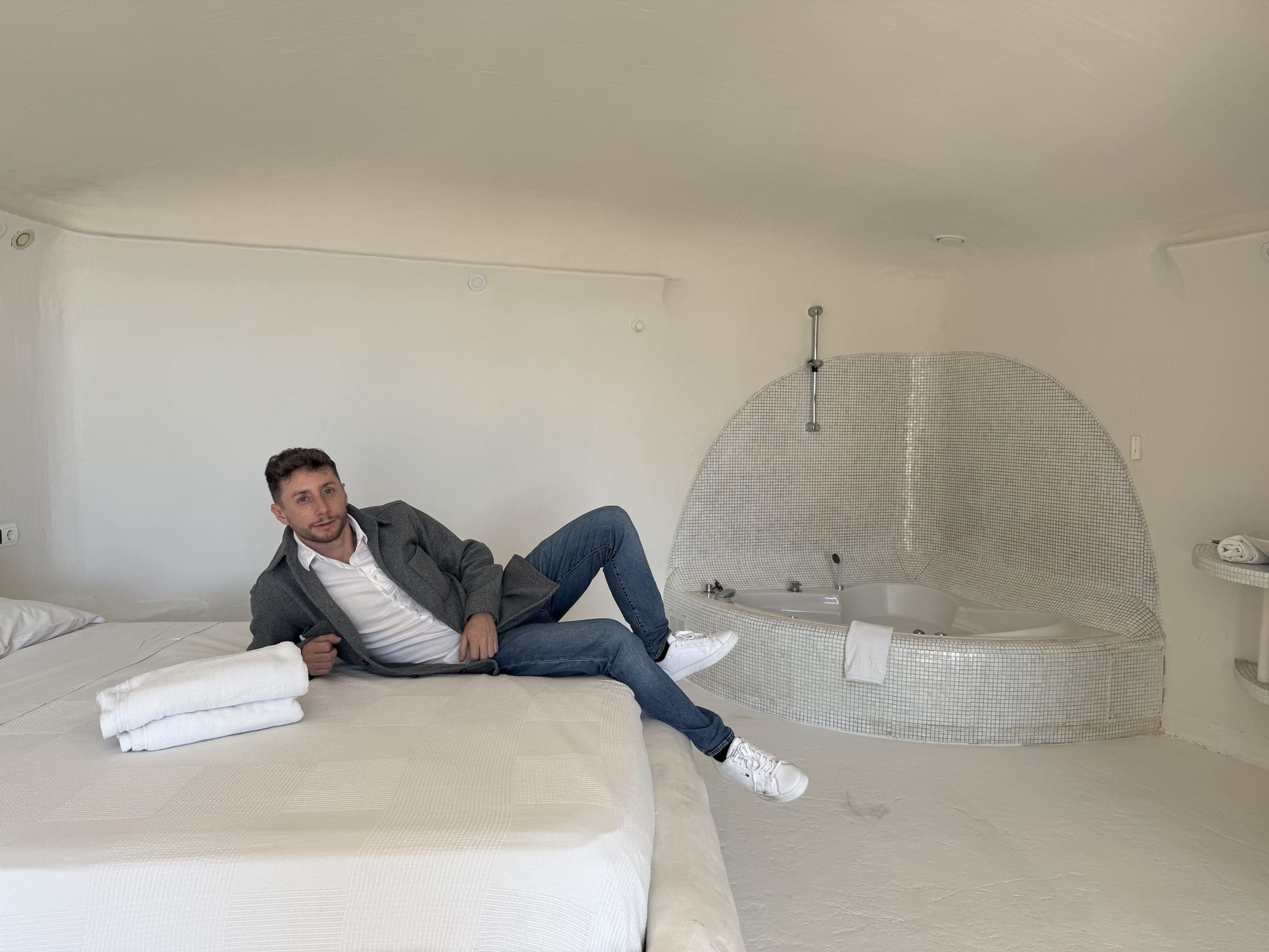 Javier Sobrino tumbado en la cama de la cueva del Hotel Spa Las Nubes, junto a la bañera de hidromasaje