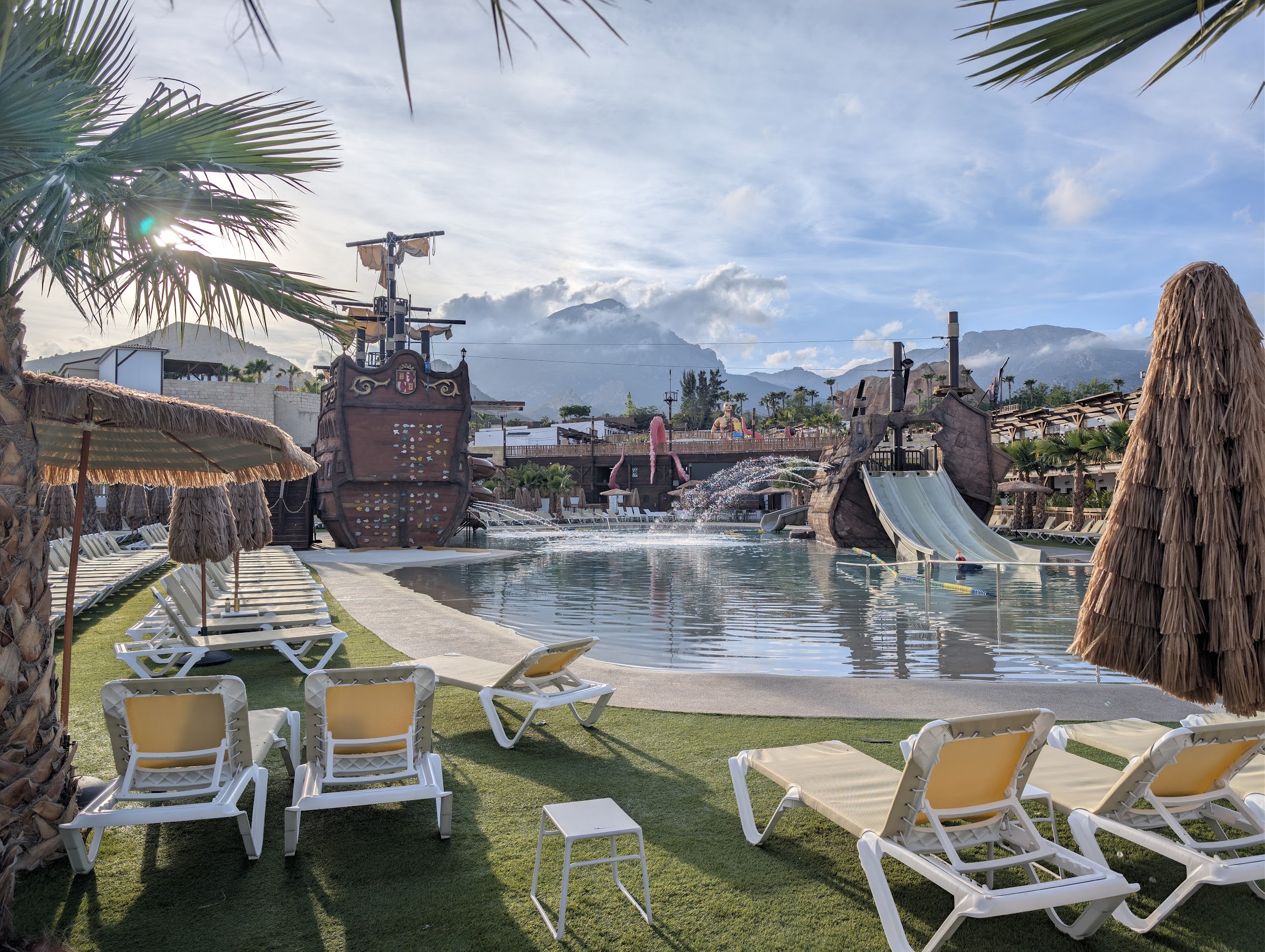 Piscina pirata del Magic Pirates Island con hamacas y barcos a última hora de la tarde