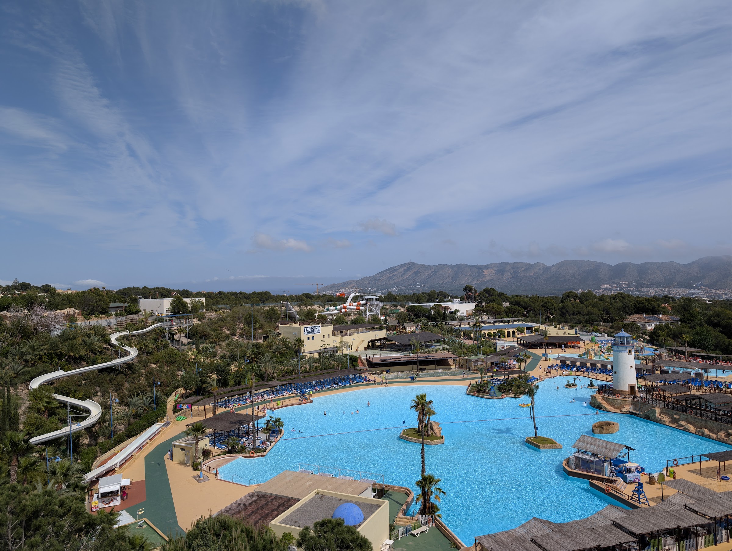 Panorámica de Aqua Natura Benidorm con lago, faro y montañas, junto al Magic Pirates Island