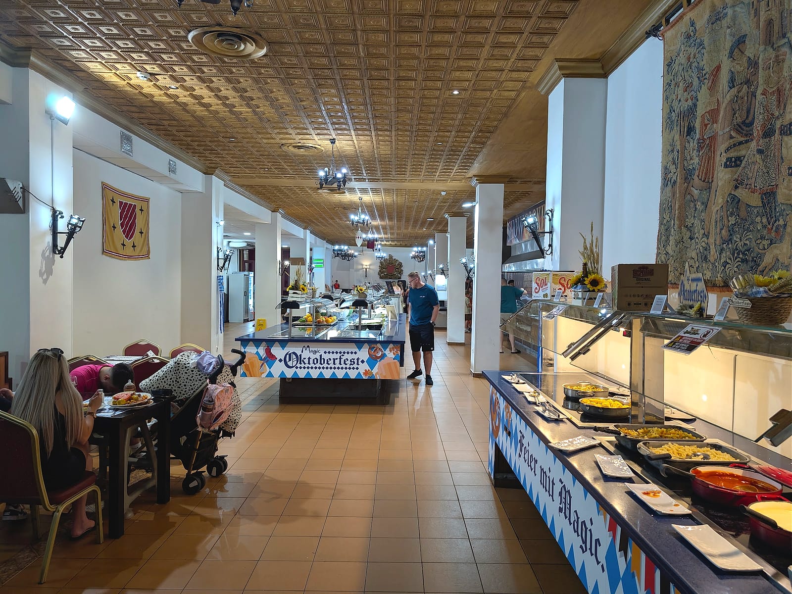El buffet del Magic Robin Hood, con techo artesonado, tapiz medieval y decoración de Oktoberfest