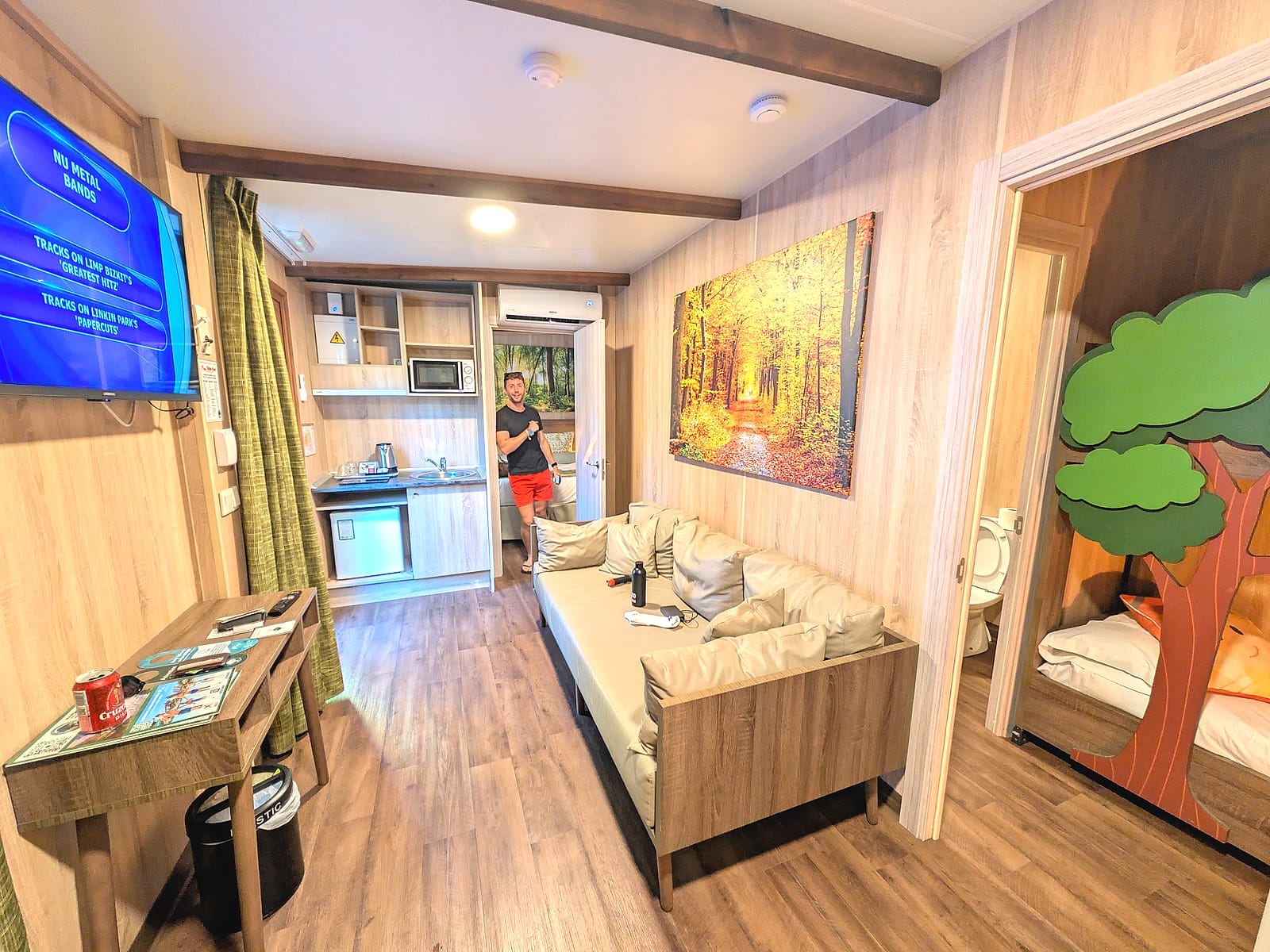 La cabaña para cuatro personas del Magic Robin Hood, con el salón y la habitación de los niños decorada con un árbol